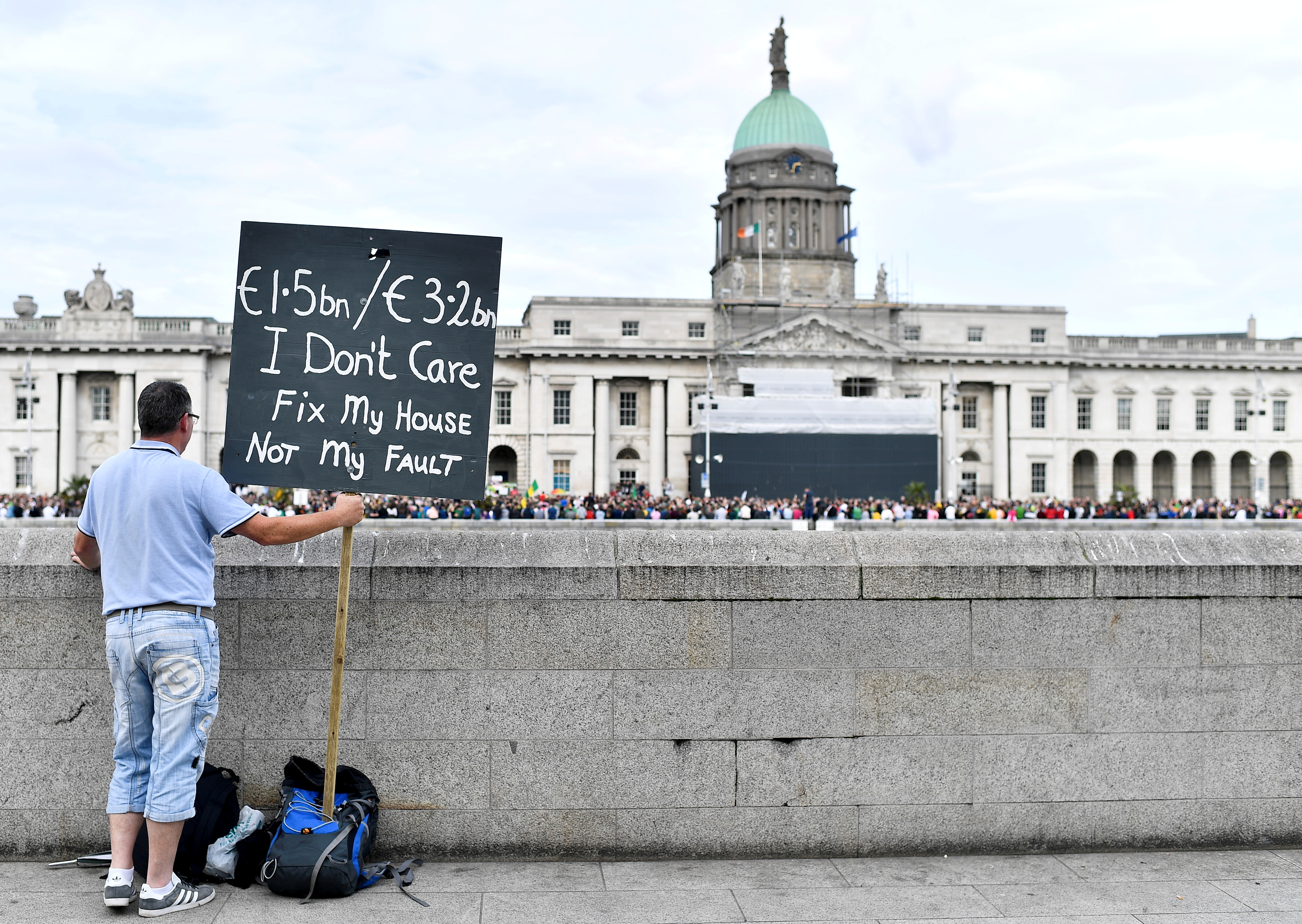 A person holds up a placard during a demonstration demanding redress for the usage of porous mica blocks in housing, in Dublin, Ireland, October 8, 2021. REUTERS/Clodagh Kilcoyne/File Photo