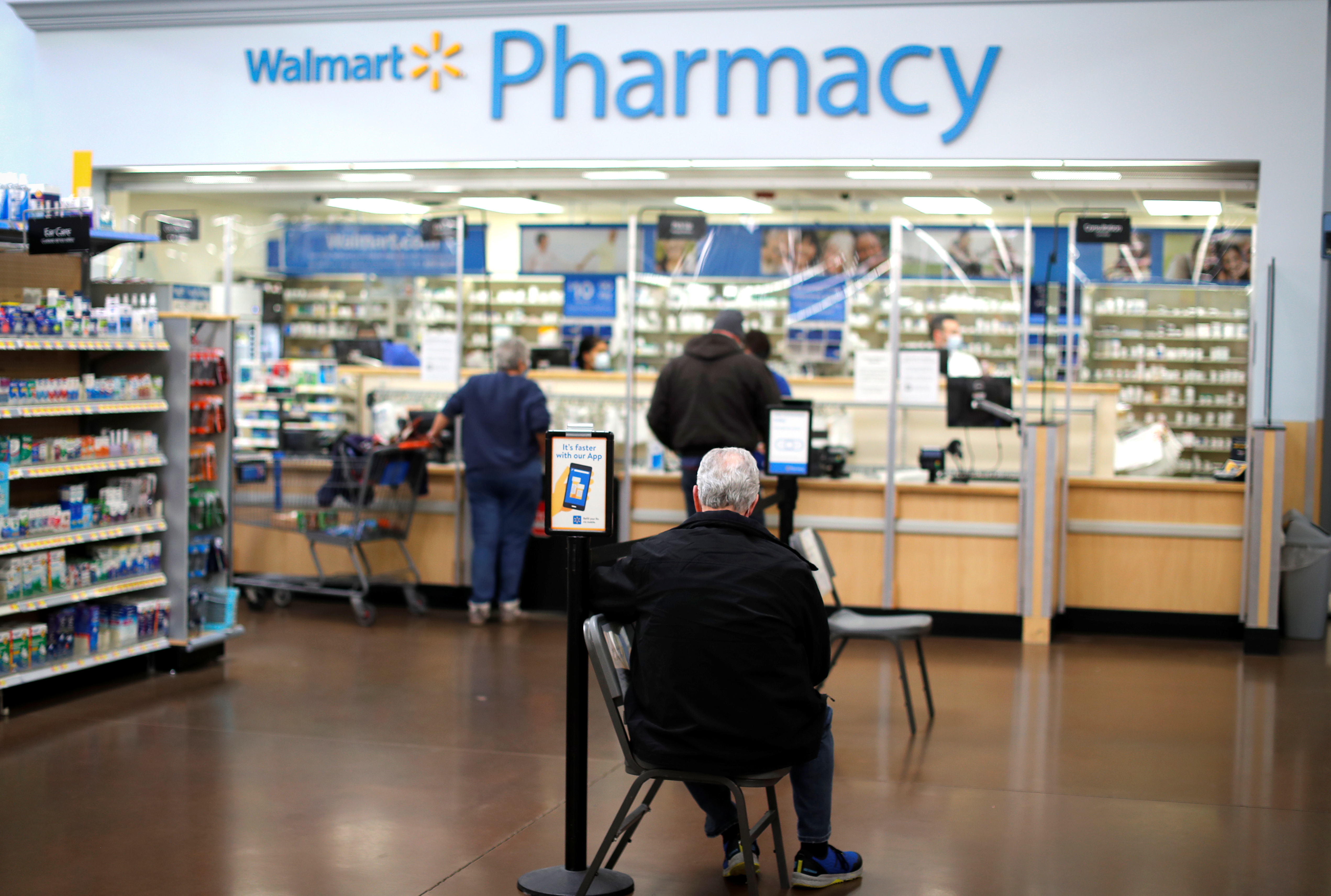 A person waits at a Walmart Pharmacy  in West Haven