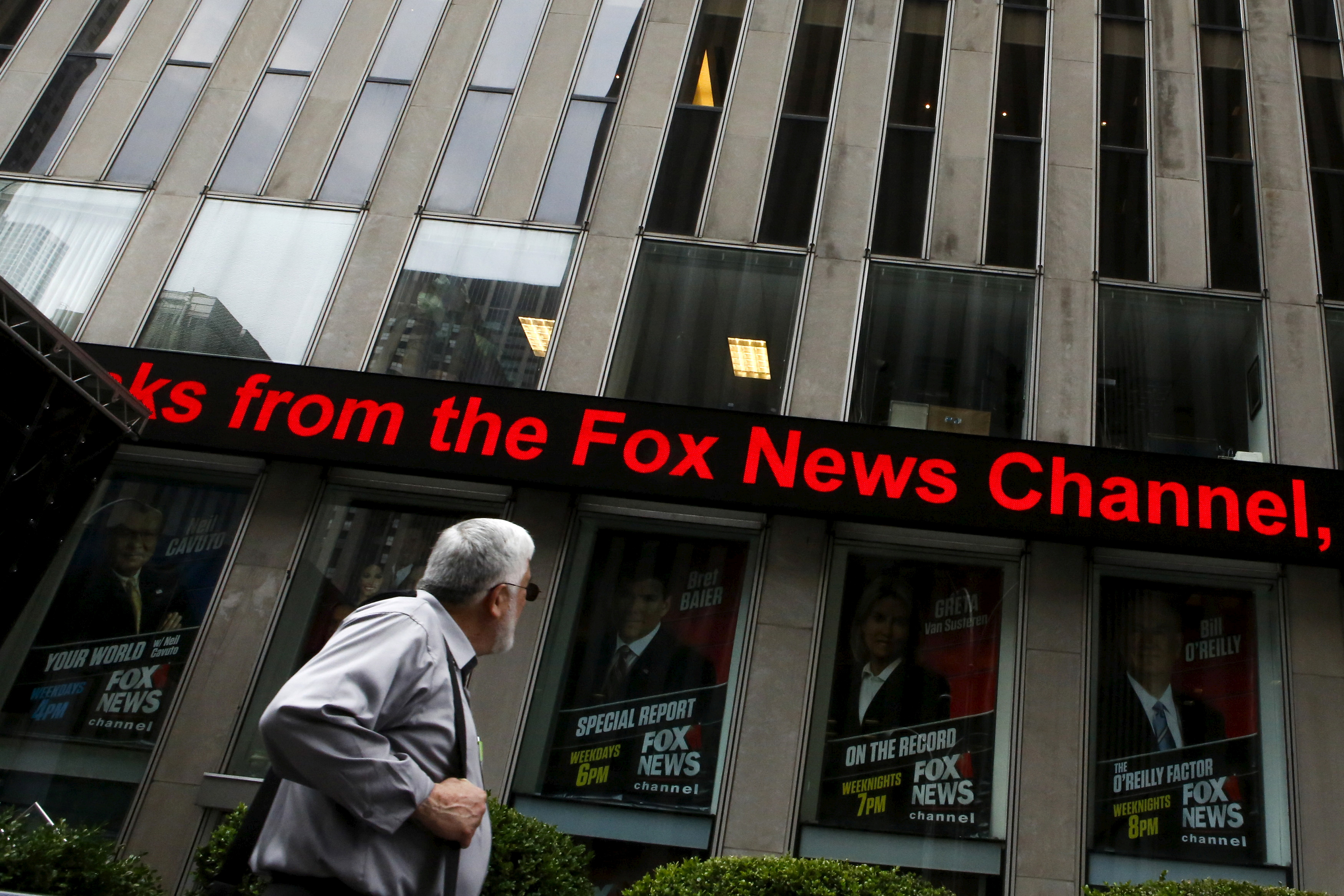 A man reads a headline at the Twenty-First Century Fox Inc headquarters in the Manhattan borough in New York