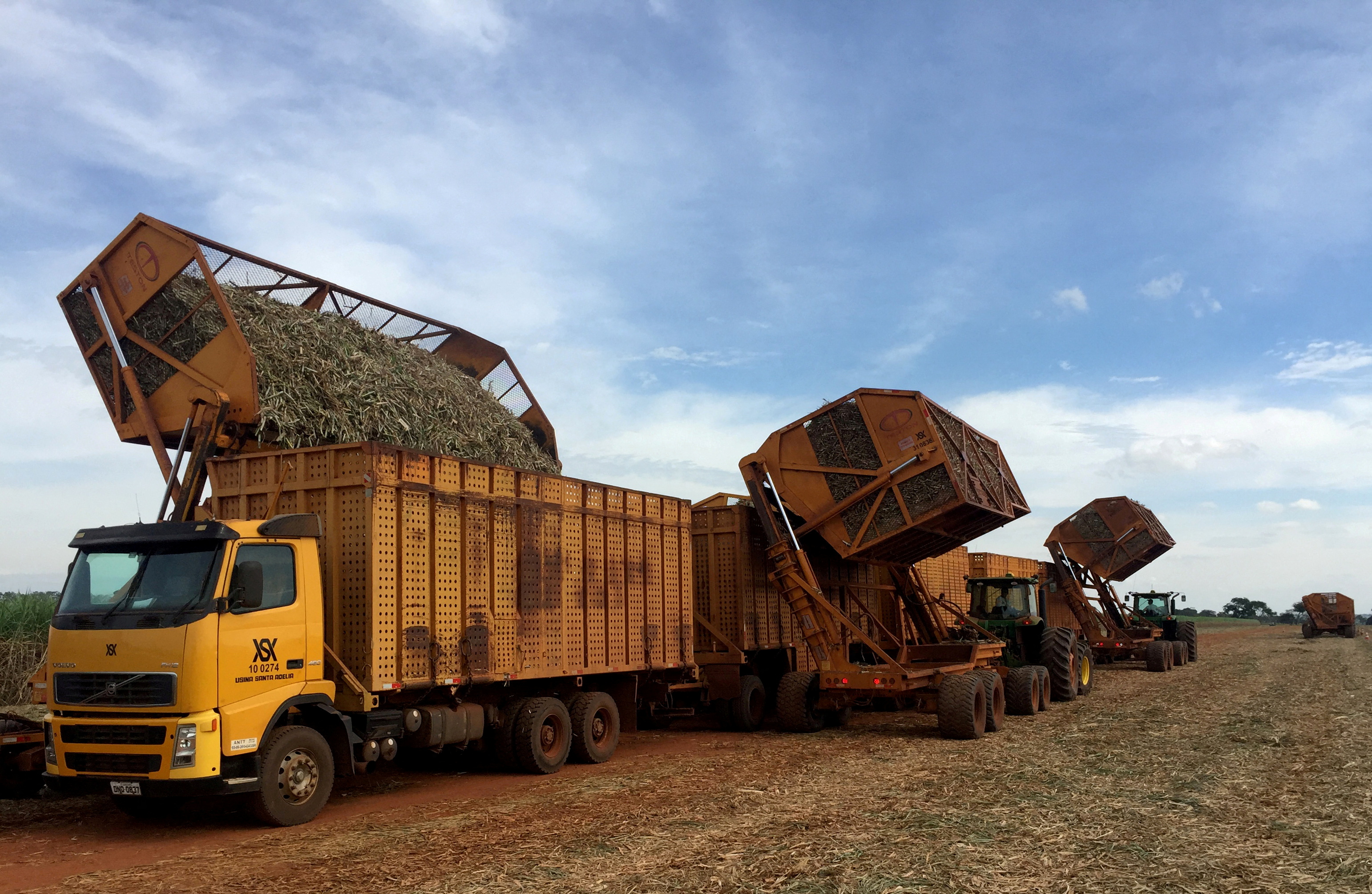 Tractors unload cane into a truck during harvest operations at Santa Adelia mill in Jaboticabal