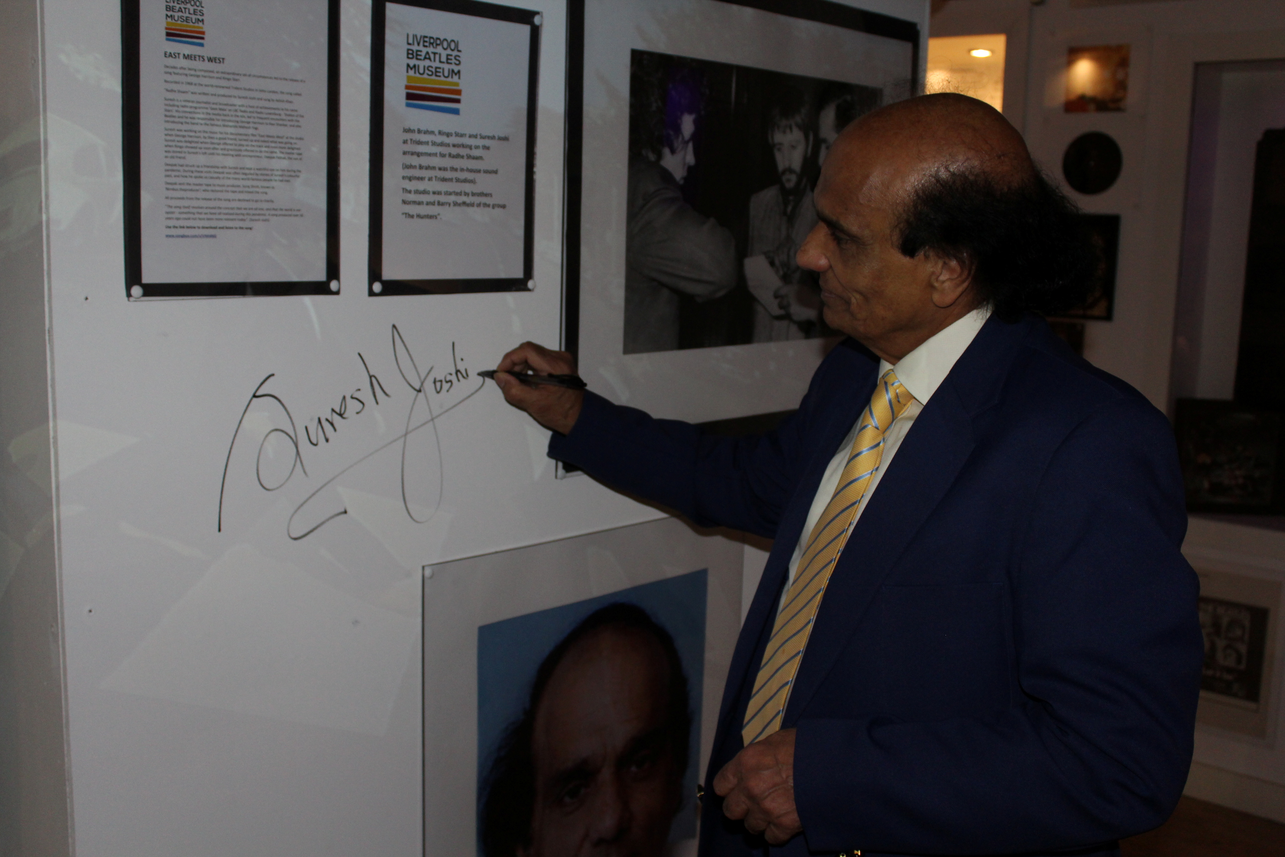Suresh Joshi signs his name at the Liverpool Beatles Museum in Liverpool