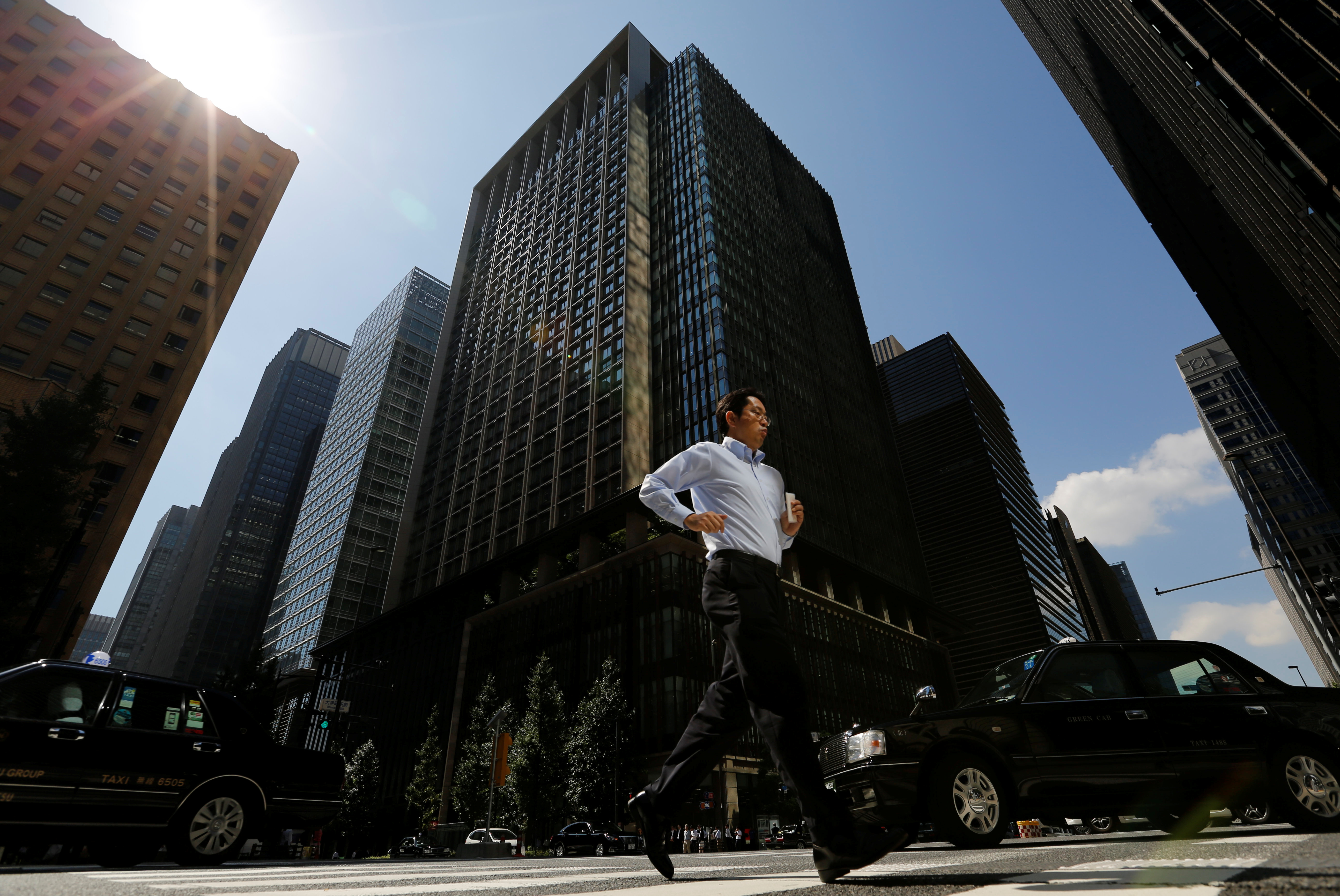 A man runs on a crosswalk at a business district in central Tokyo