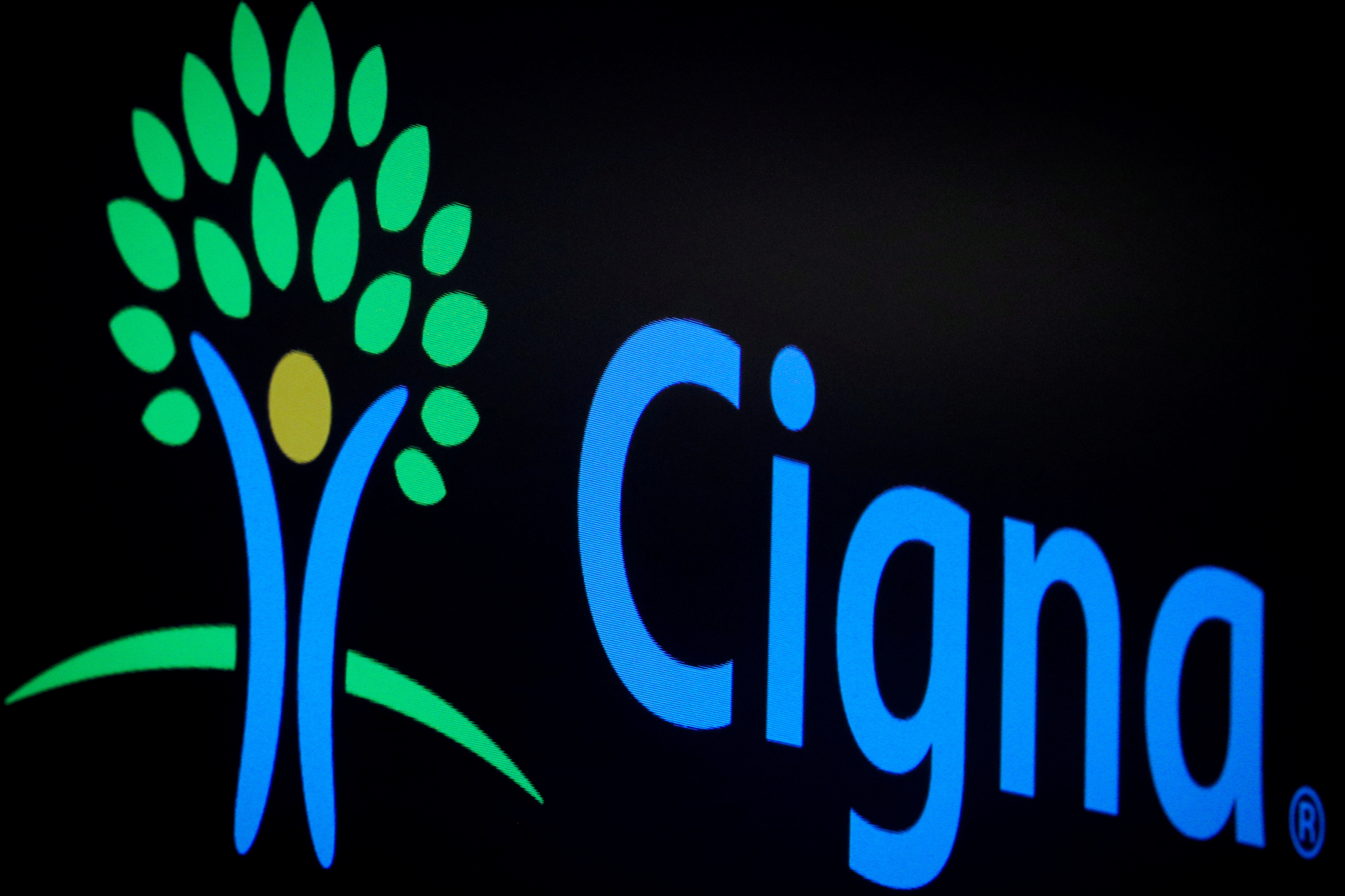 A screen displays the logo for Cigna Corp. on the floor at the NYSE in New York