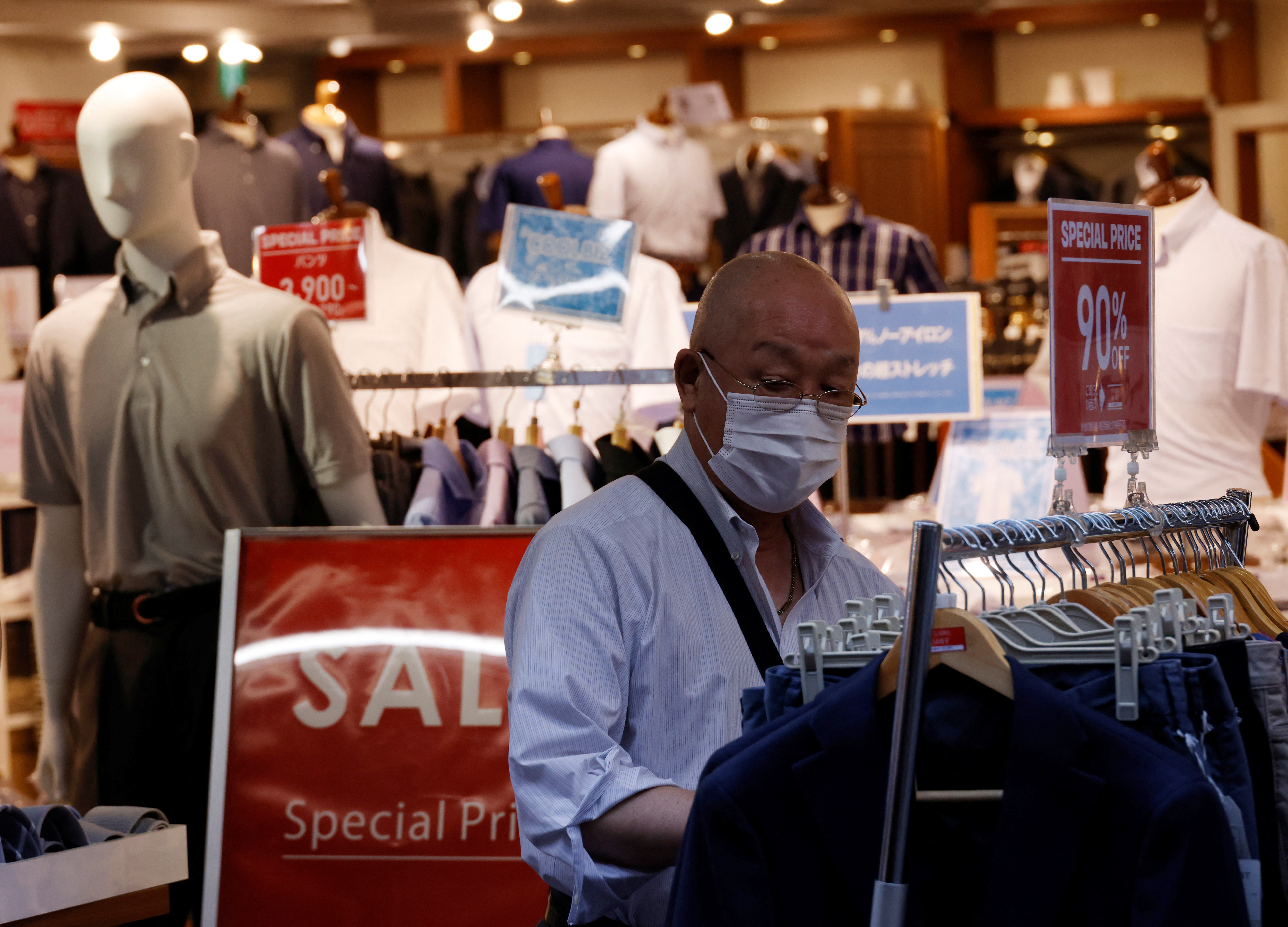 A customer chooses clothes at a shop at the Ameyoko shopping district in Tokyo