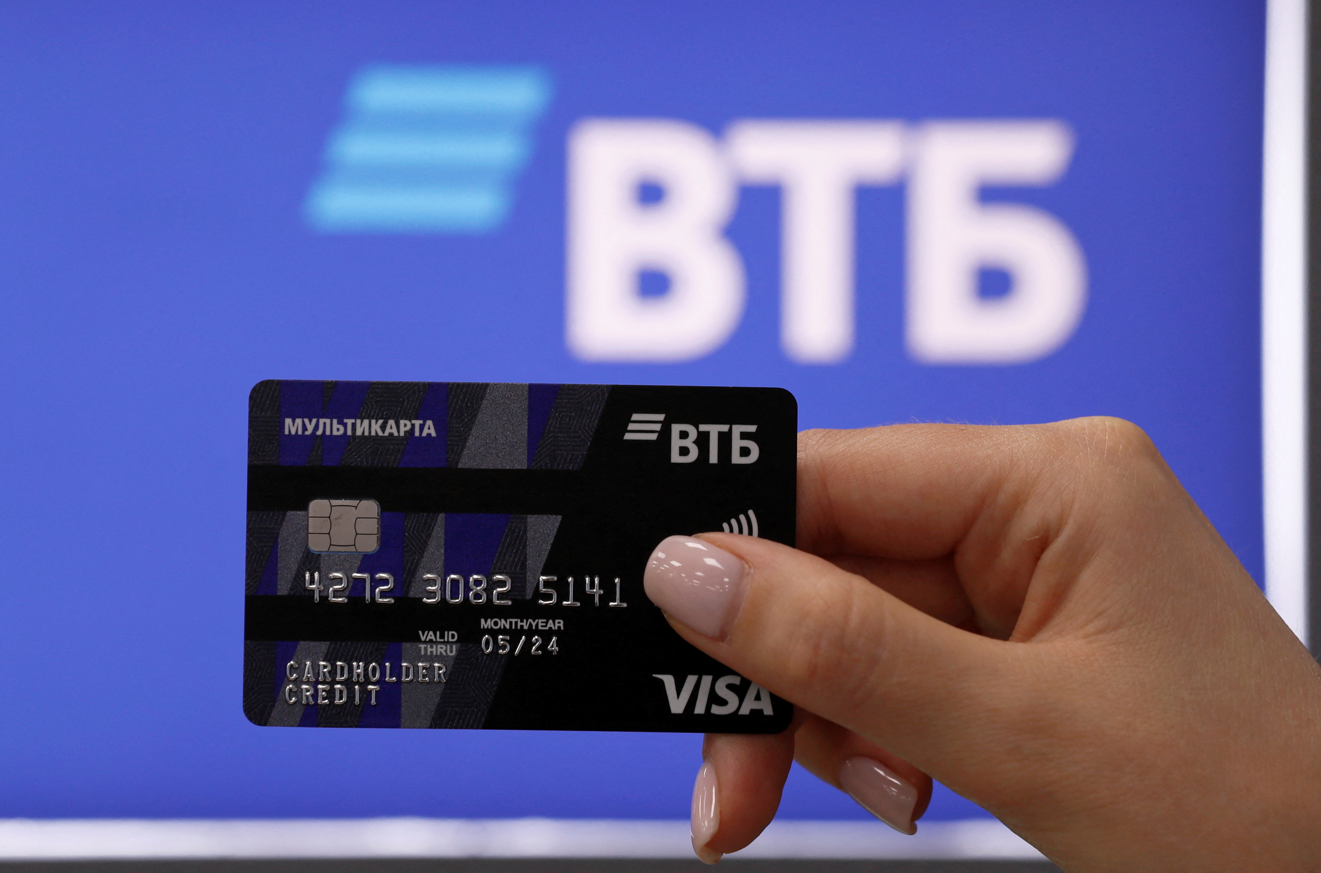An employee demonstrates a payment card at a branch of VTB bank in Moscow