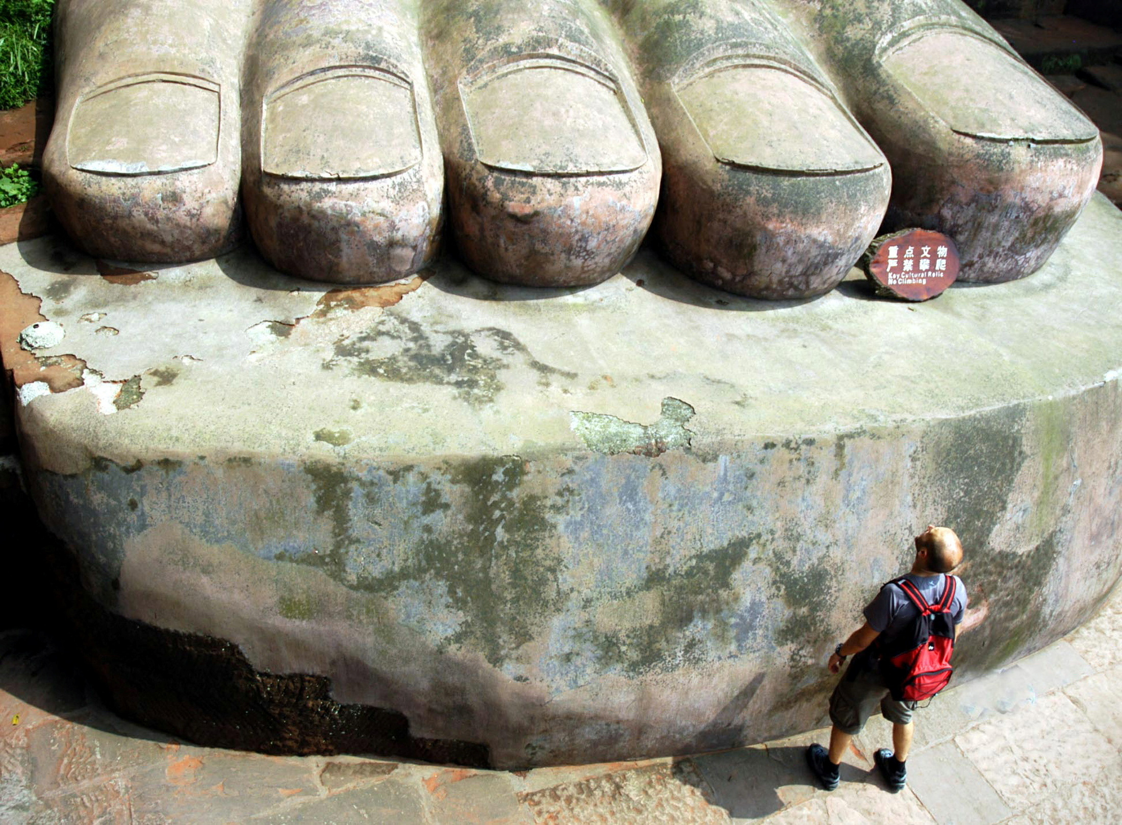 A visitor looks at the foot of the Leshan Giant Buddha statue in Leshan in southwest China's Sichuan..