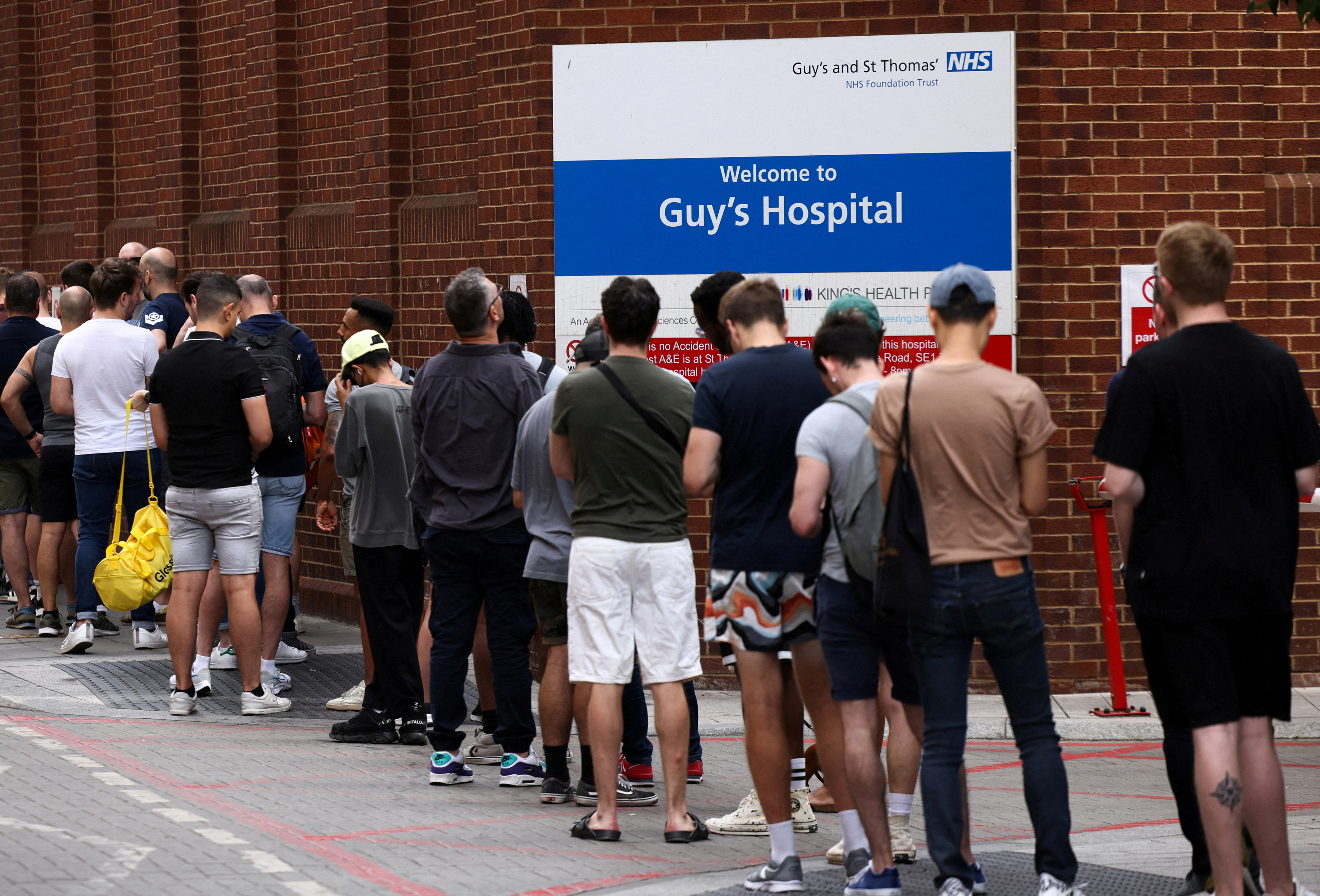 People queue up to receive monkeypox vaccinations during a pop-up clinic at Guy's Hospital in central London