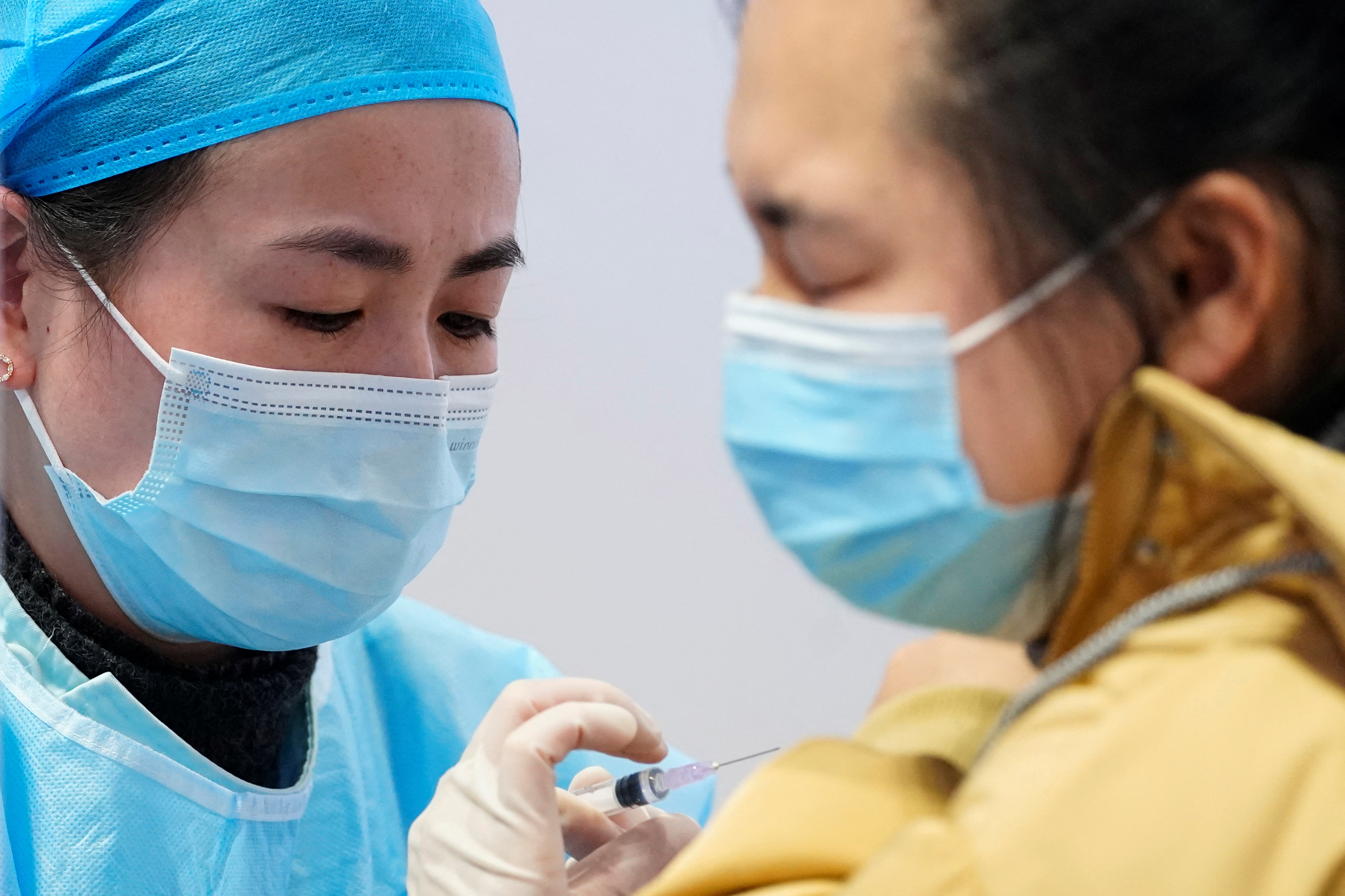 A medical worker prepares to administer a dose of a coronavirus disease (COVID-19) vaccine to a woman at a vaccination site, during a government-organised visit, following the coronavirus disease (COVID-19) outbreak, in Shanghai, China January 19, 2021. REUTERS/Aly Song - RC2WAL9RG72Y