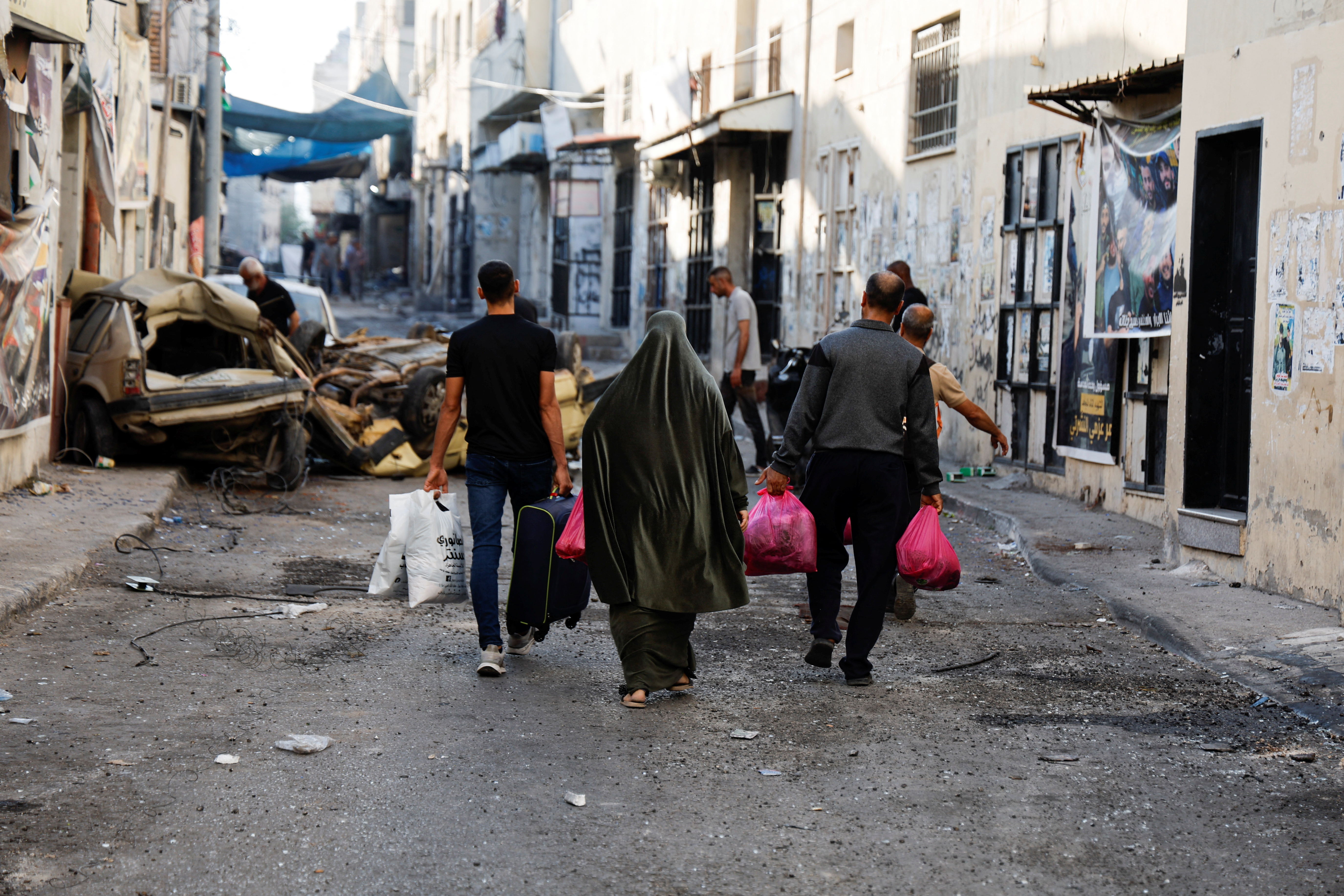 People carry their belongings on the street after the Israeli army's withdrawal from the Jenin camp