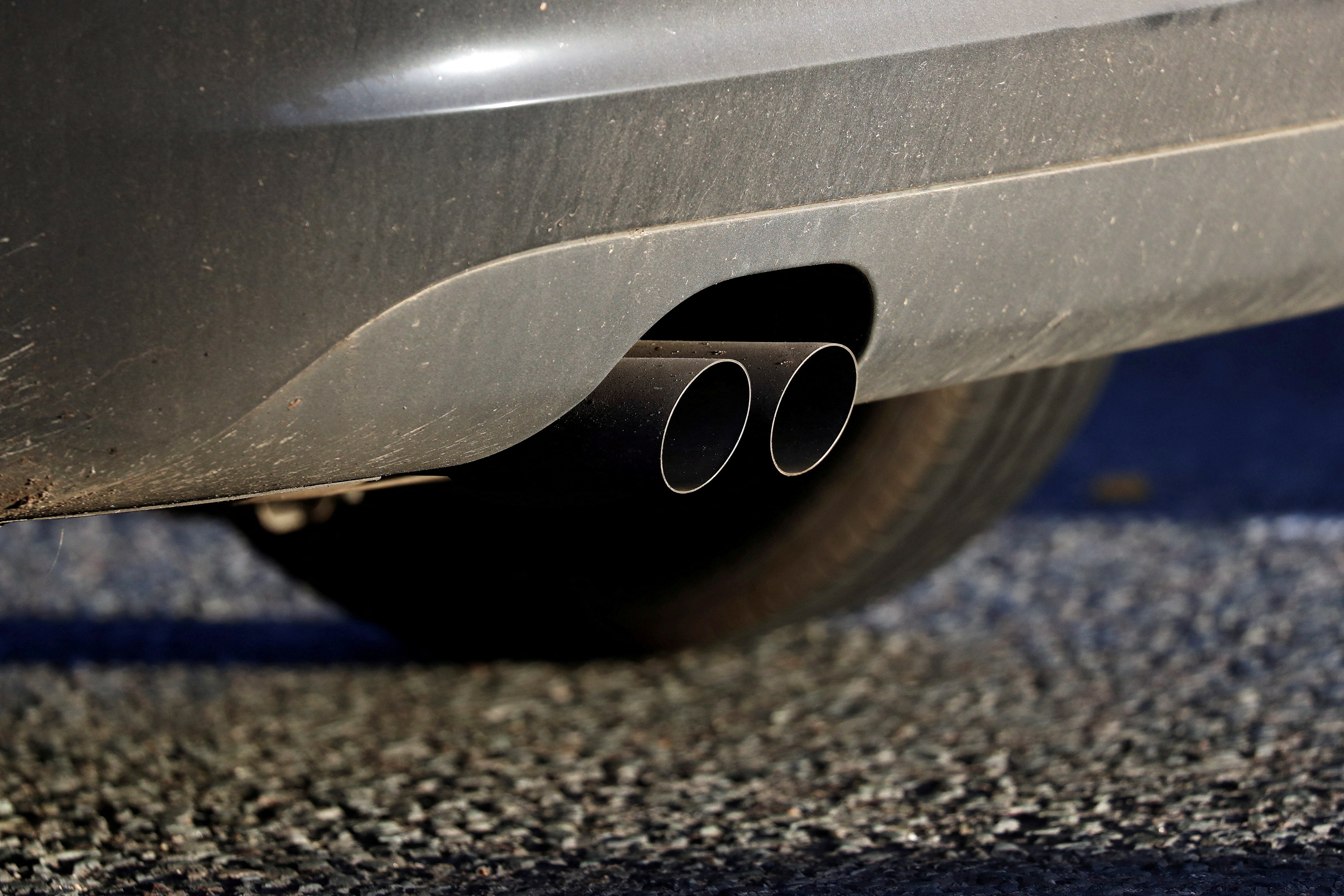 An exhaust pipe is seen as a car sits in traffic near the Blackwall Tunnel in London