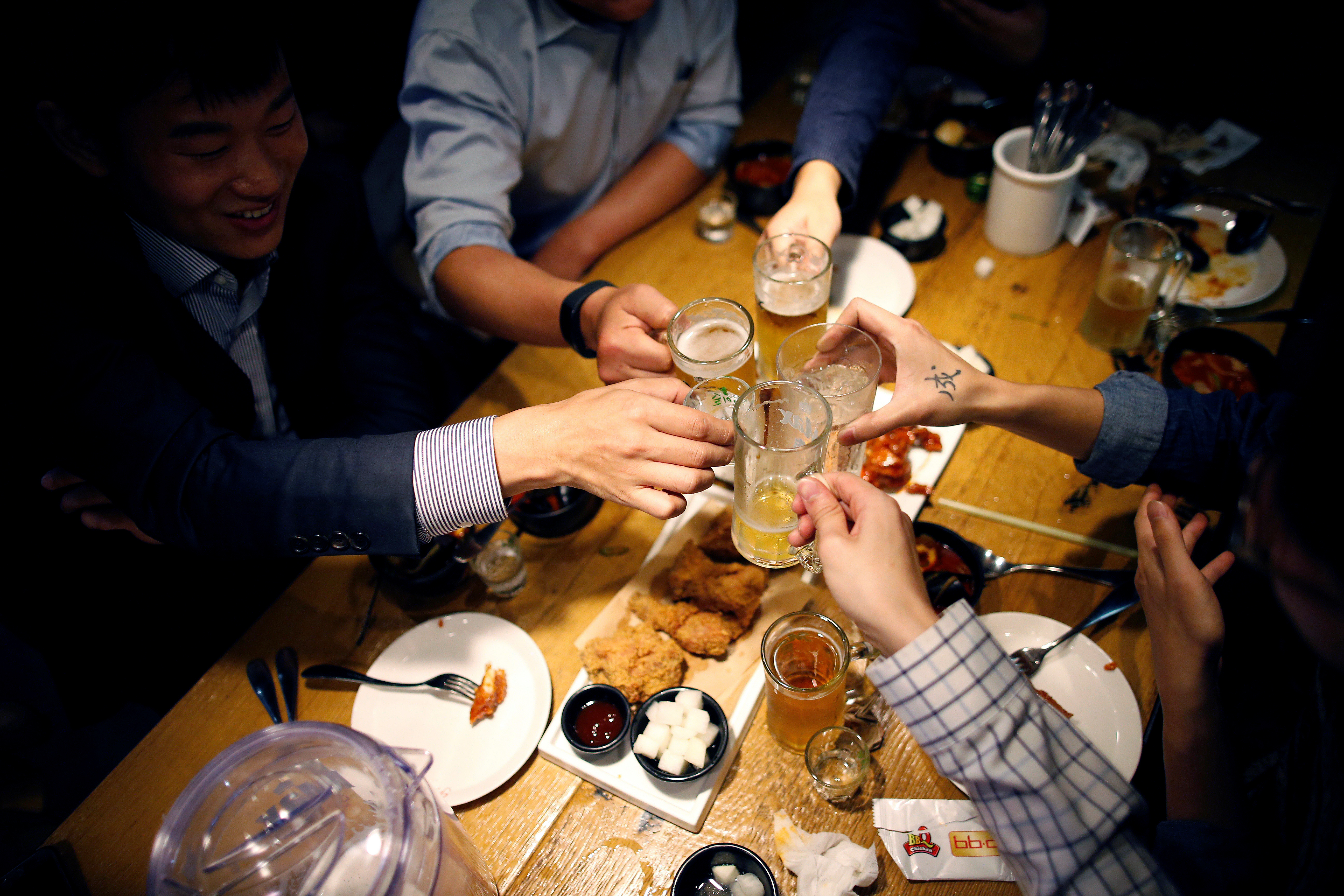 People make a toast at a pub in Seoul