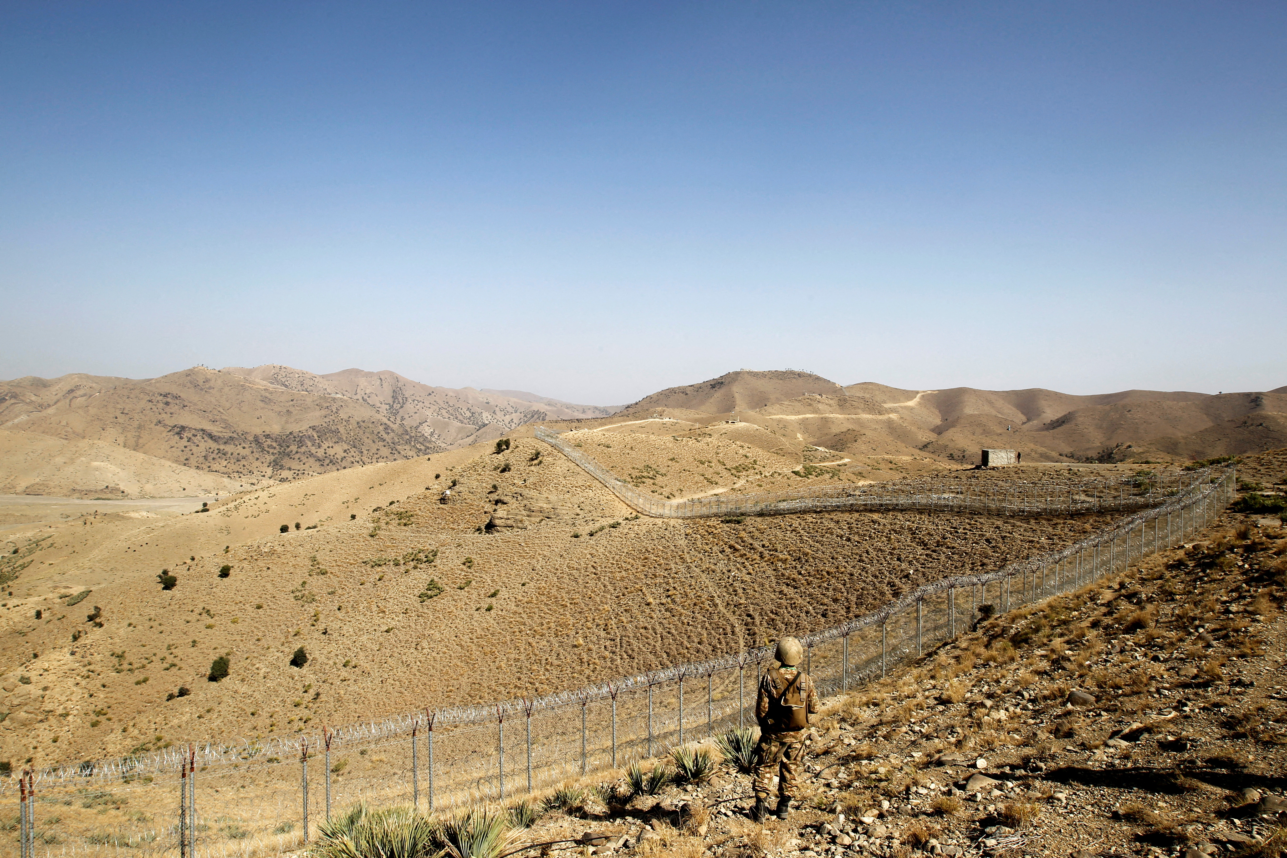 A Pakistani soldier stands guard along the border fence outside the Kitton outpost on the border with Afghanistan in North Waziristan, Pakistan October 18, 2017. REUTERS/Caren Firouz/File Photo/File Photo