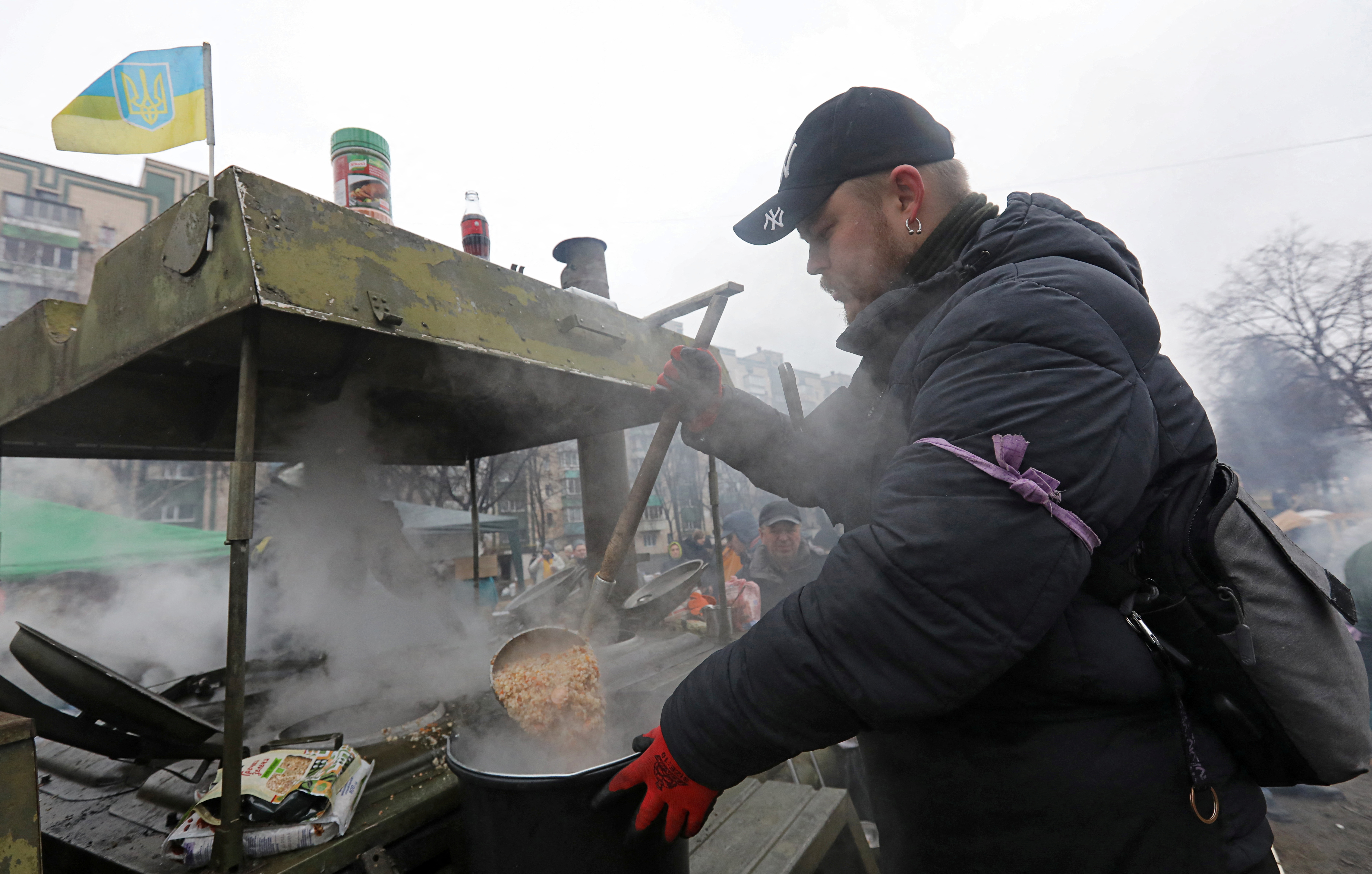A man prepares food for local residents and members of the Territorial Defence Forces at a field kitchen in Kyiv