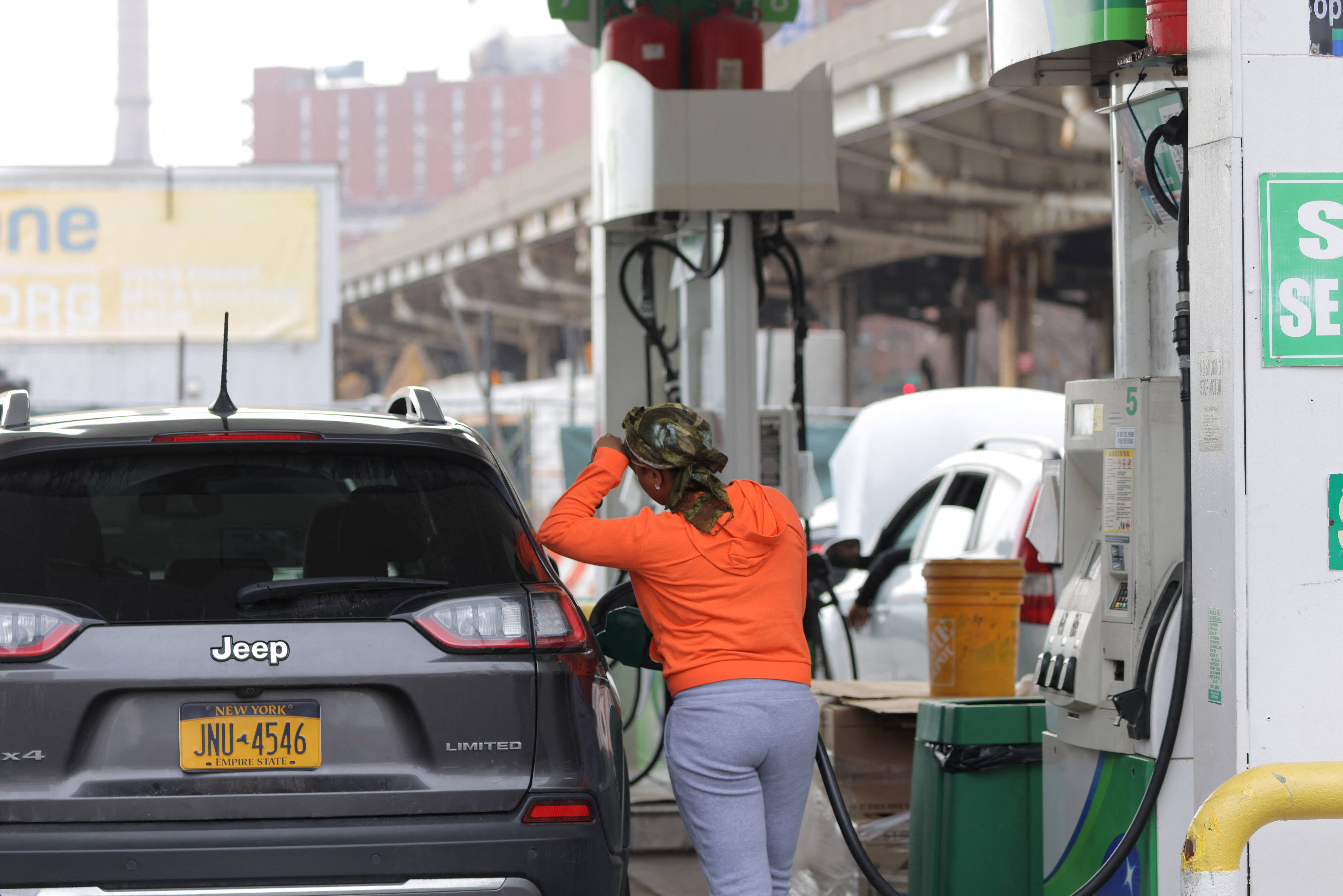 A person uses a petrol pump at a gas station as fuel prices surged in Manhattan, New York City