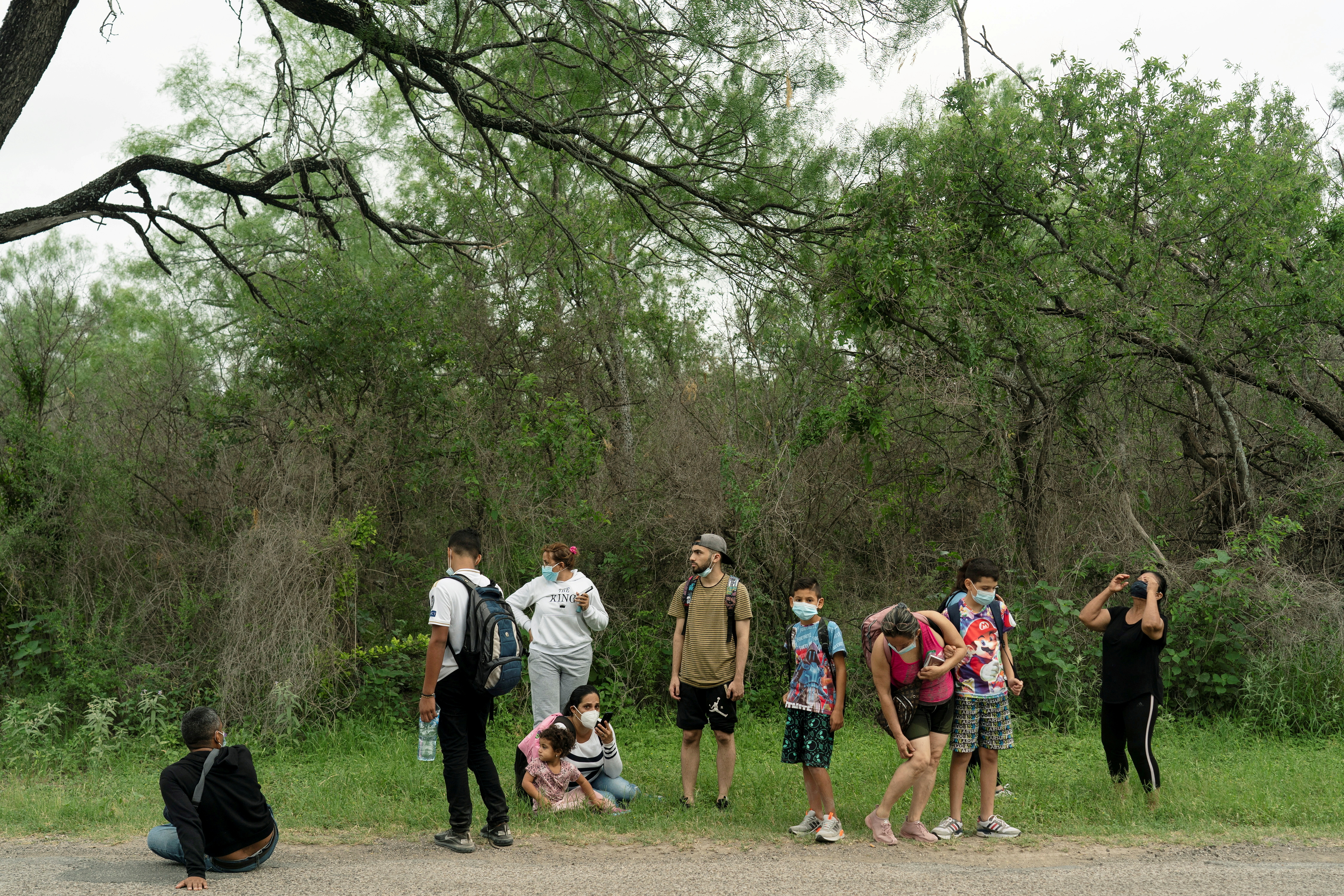 Asylum-seeking migrants' families from Venezuela wait to be transported by the U.S. Border Patrols after crossing the Rio Grande river into the United States from Mexico in Del Rio, Texas, U.S., May 27, 2021. REUTERS/Go Nakamura/File Photo