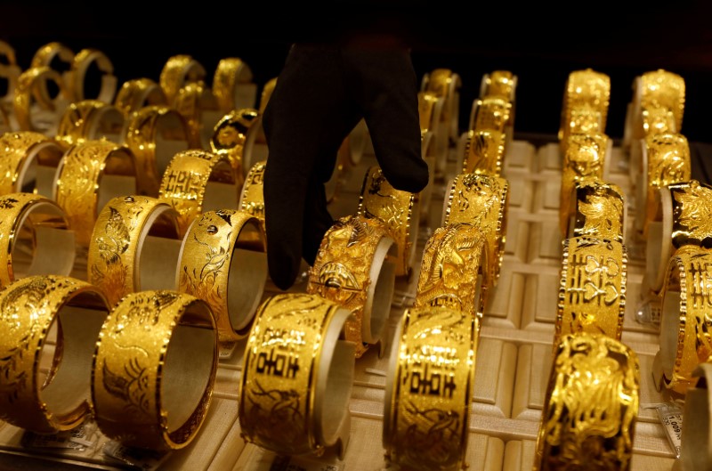 A salesperson arranges 24K gold bracelets for Chinese weddings at Chow Tai Fook Jewellery store in Hong Kong