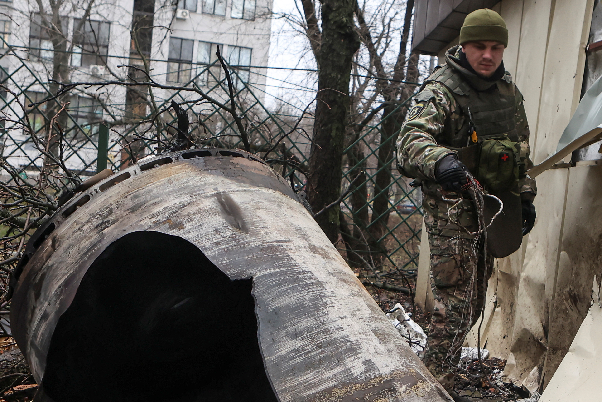 A bomb squad member works next to remains of an unidentified missile at the site where residential buildings were heavily damaged during a Russian missile attack in Kharkiv