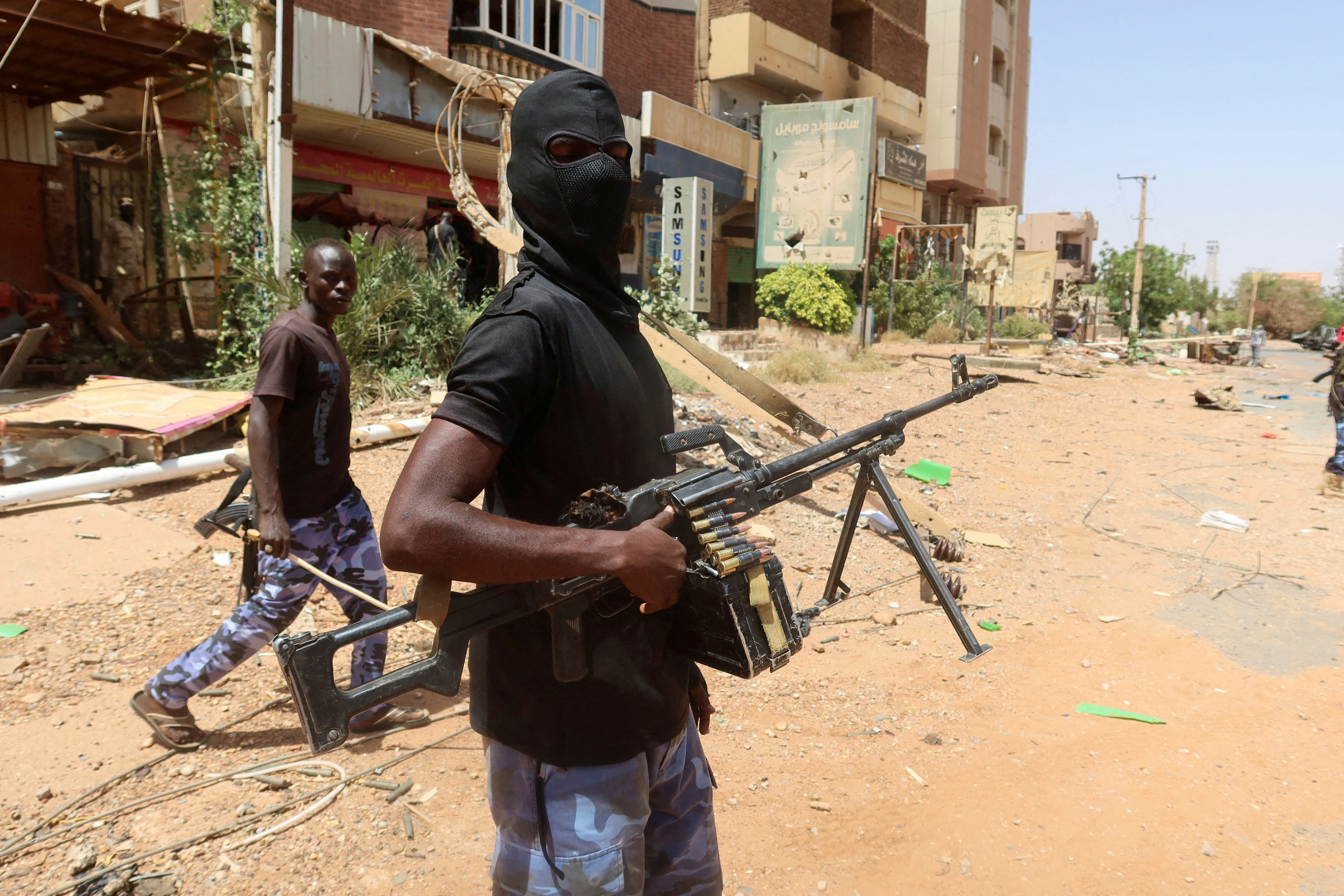 A member of Sudanese armed forces looks on as he holds his weapon in the street in Omdurman
