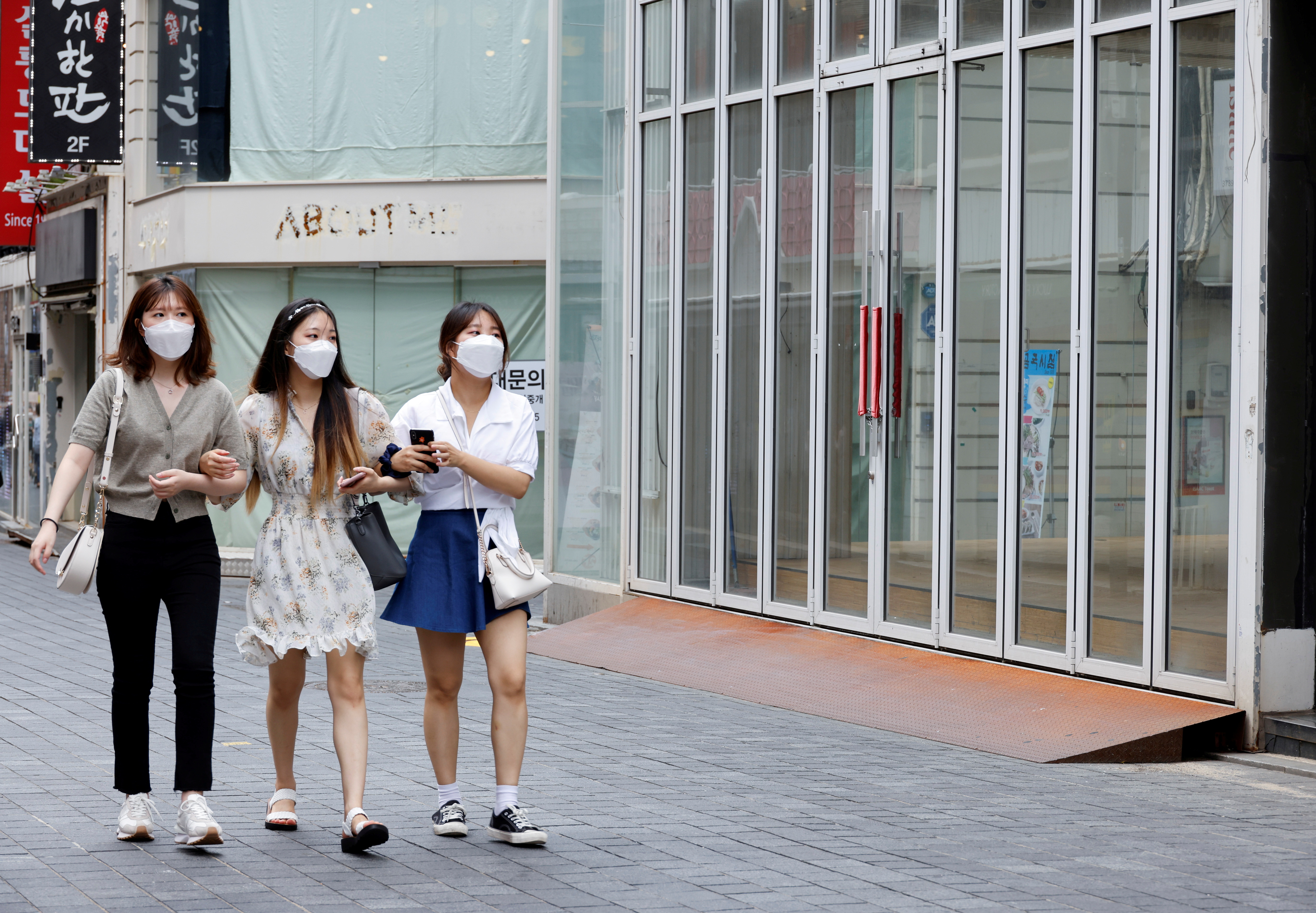 Women wearing masks walk in a shopping district amid the coronavirus disease (COVID-19) pandemic in Seoul