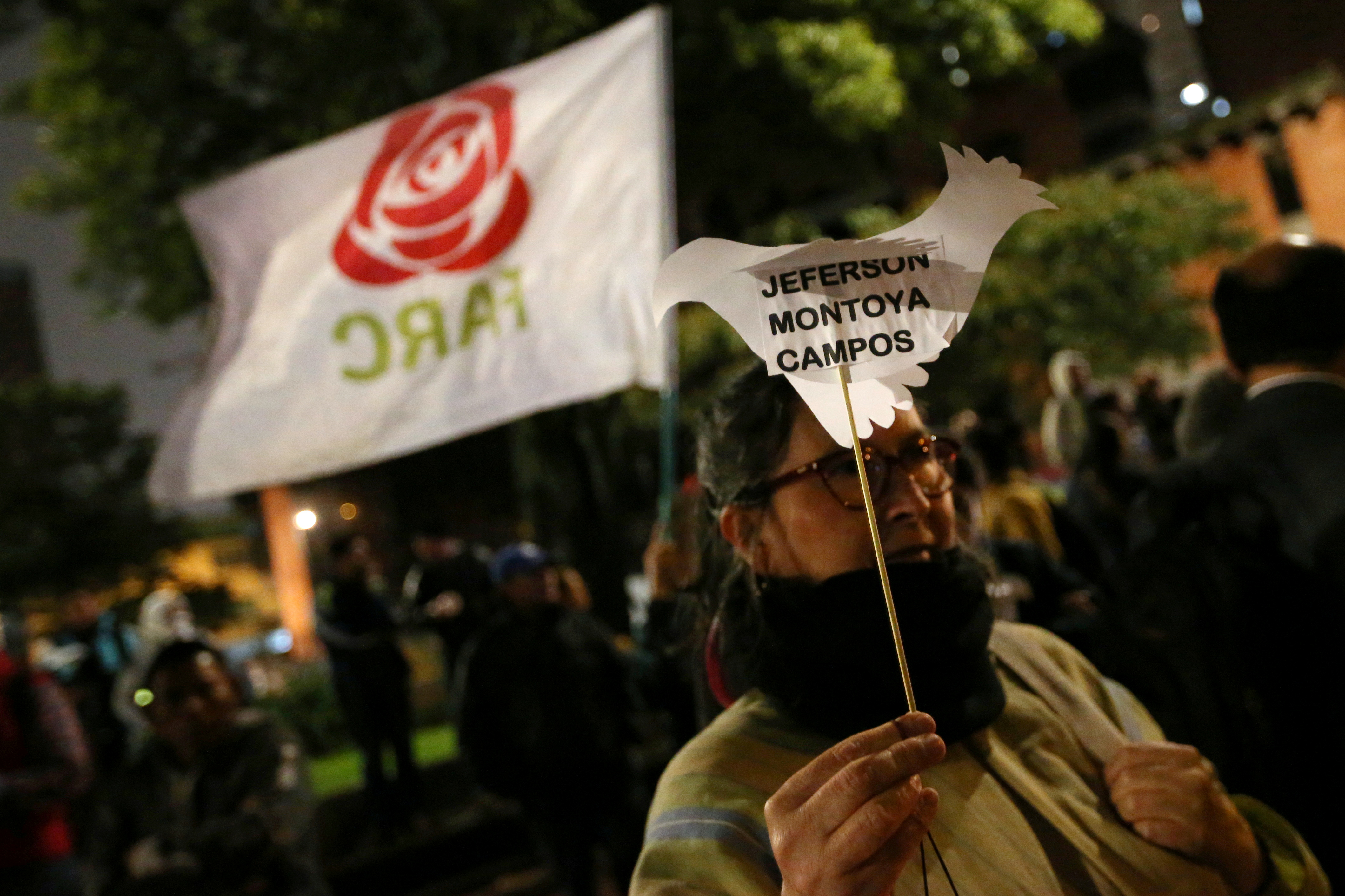 Revolutionary Alternative Force of the Common rebel holds a paper dove with the name of a former rebel during a vigil in memory of former FARC guerrillas killed after the peace agreement made with the government in Bogota