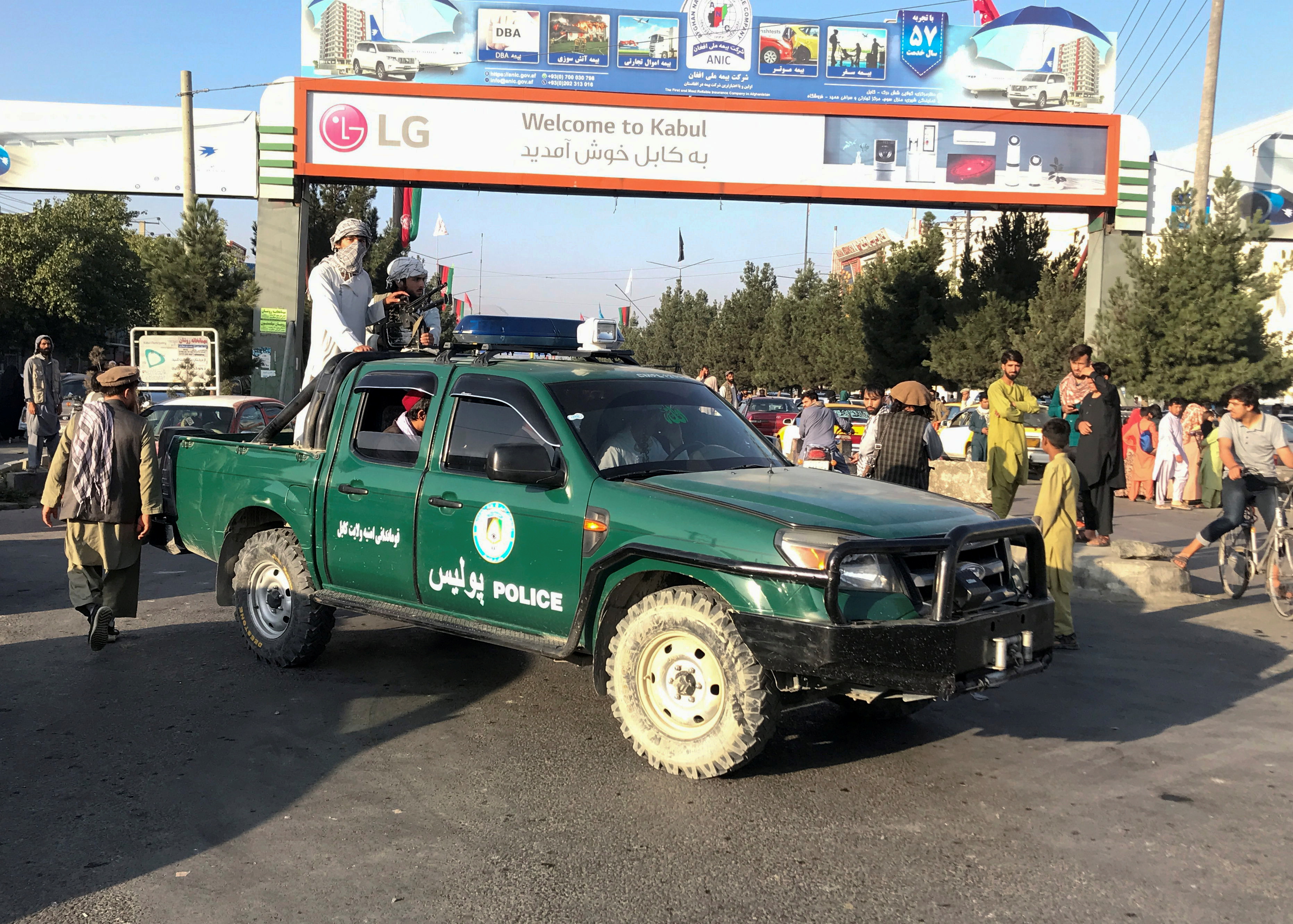 Taliban fighters ride on a police vehicle outside Hamid Karzai International Airport in Kabul, Afghanistan, August 16, 2021.REUTERS/Stringer