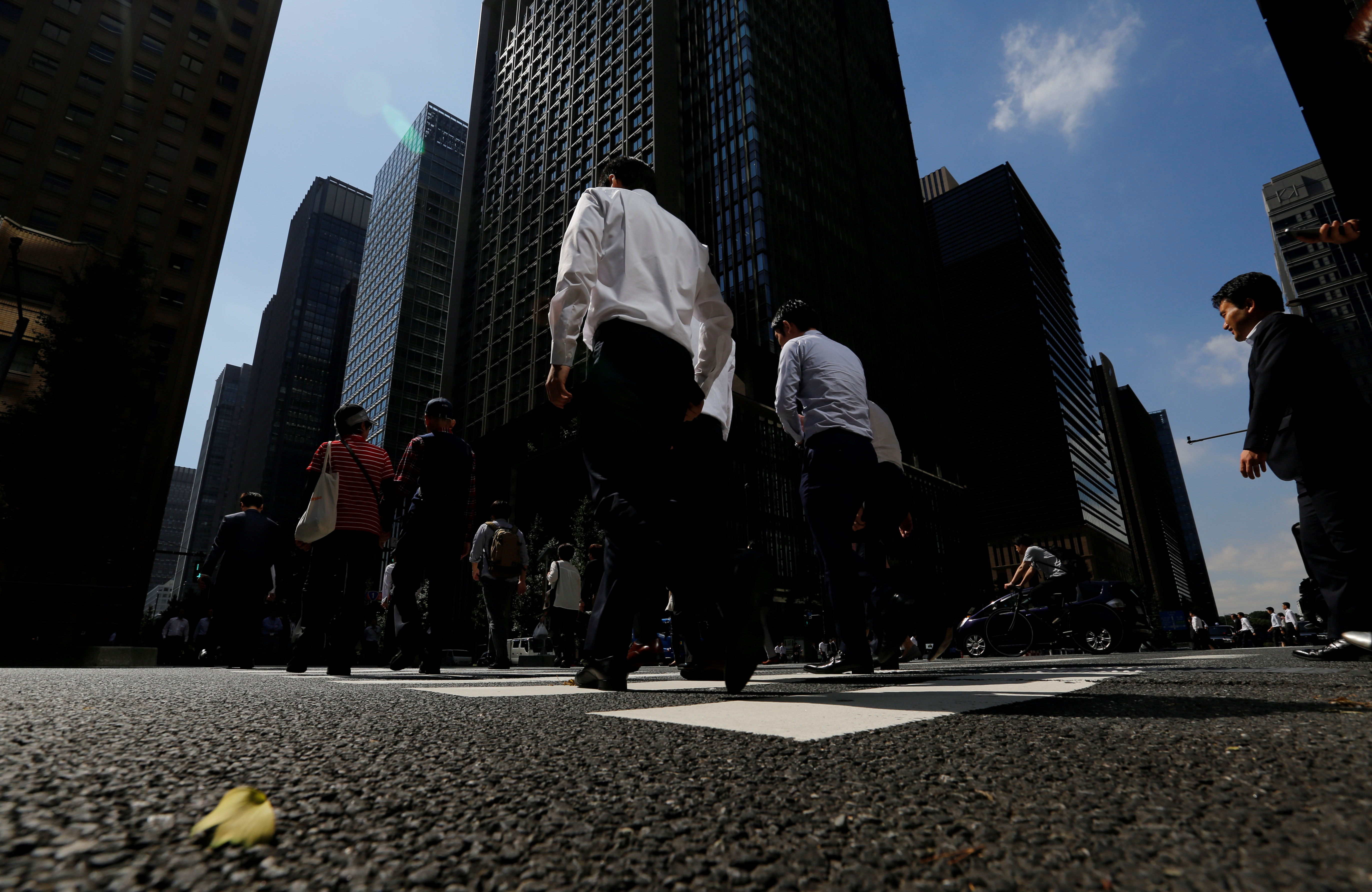 People walk on a crosswalk at a business district in central Tokyo