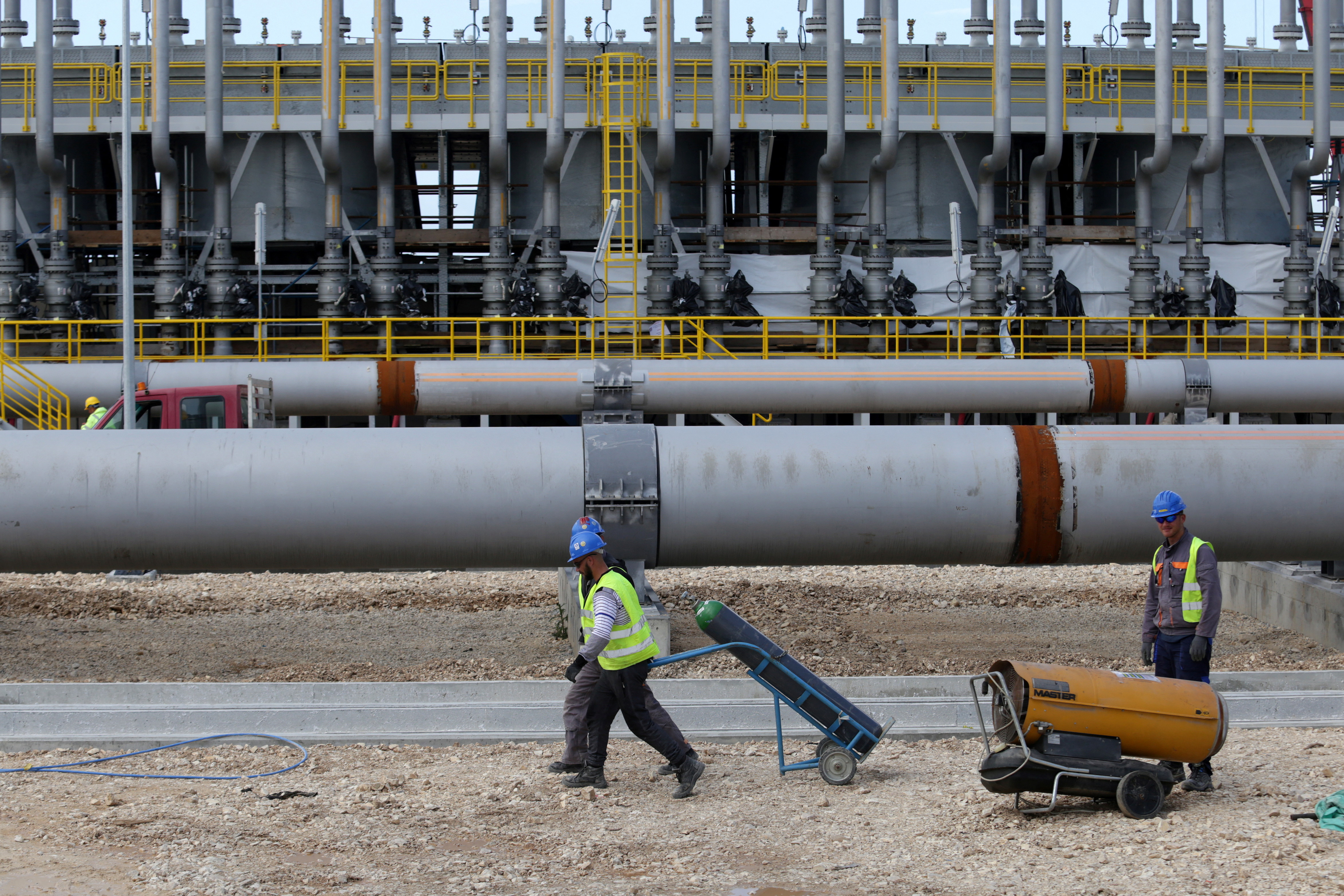 Local employees work at a compressor station of the Trans Adriatic Pipeline in Seman