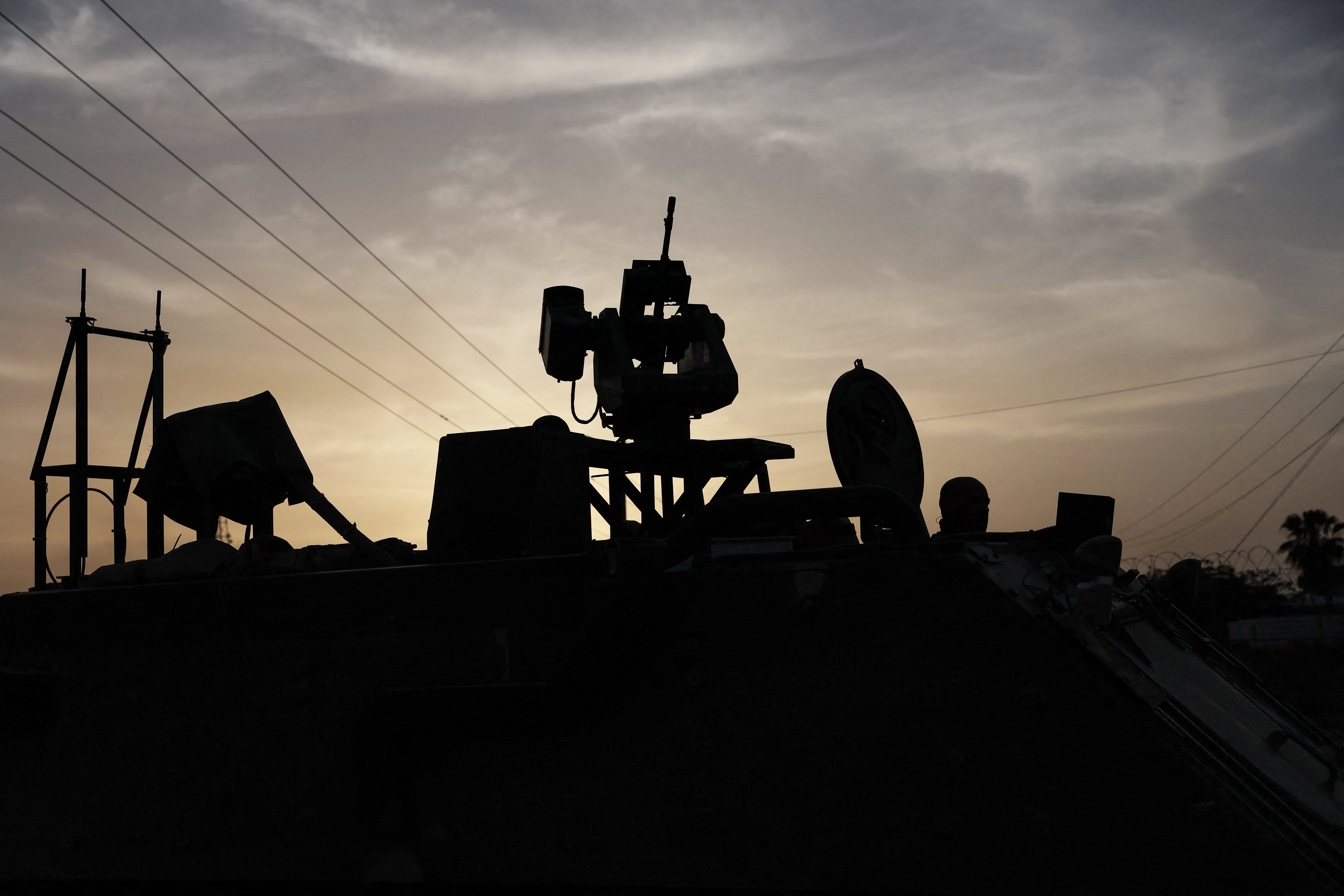 An Israeli solider is seen in silhouette inside an armored personnel carrier, as military operations continue in the southern Gaza city of Rafah, at an area outside Kerem Shalom, Israe