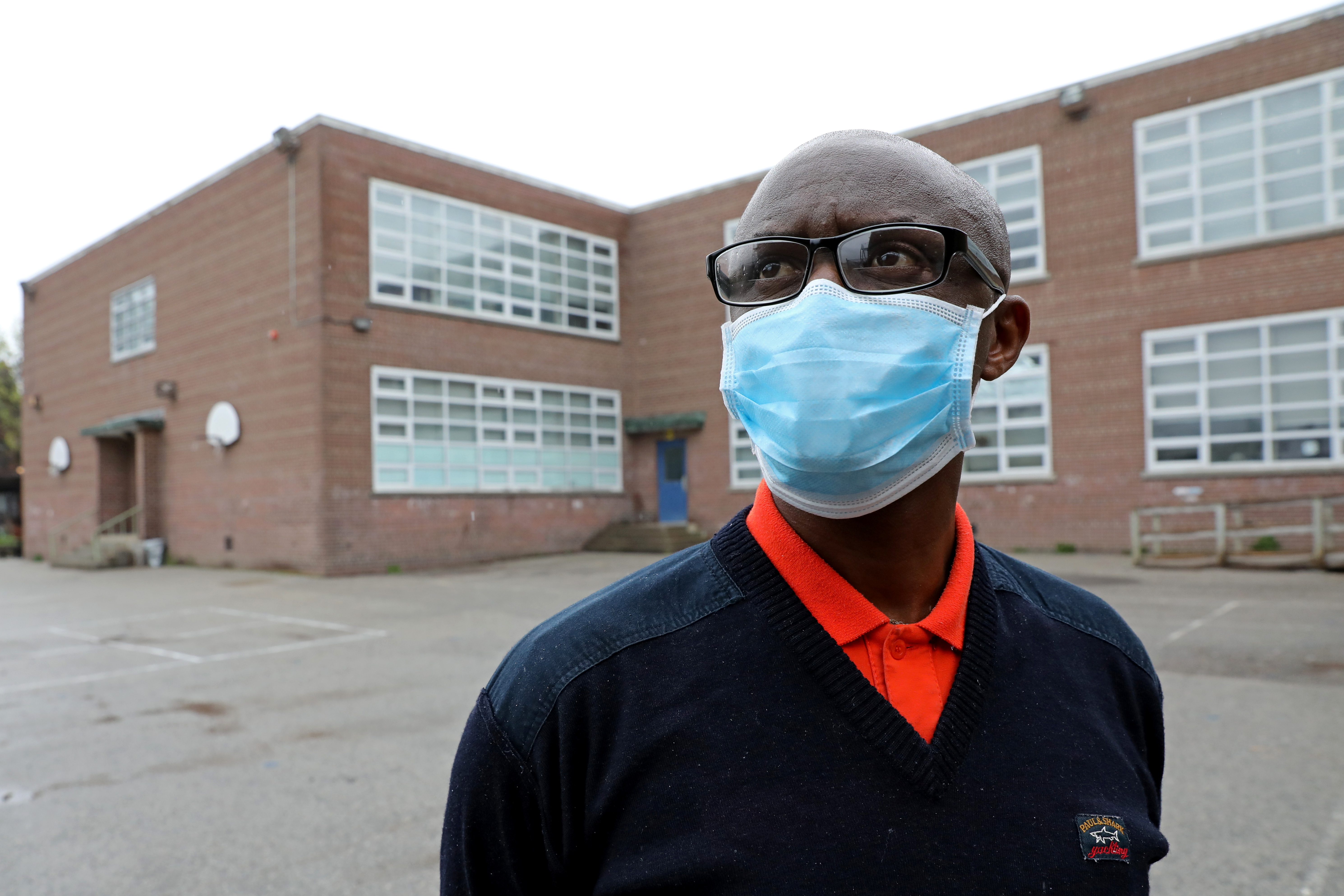 Apollinaire Nduwimana poses outside a school near his lodging in Toronto