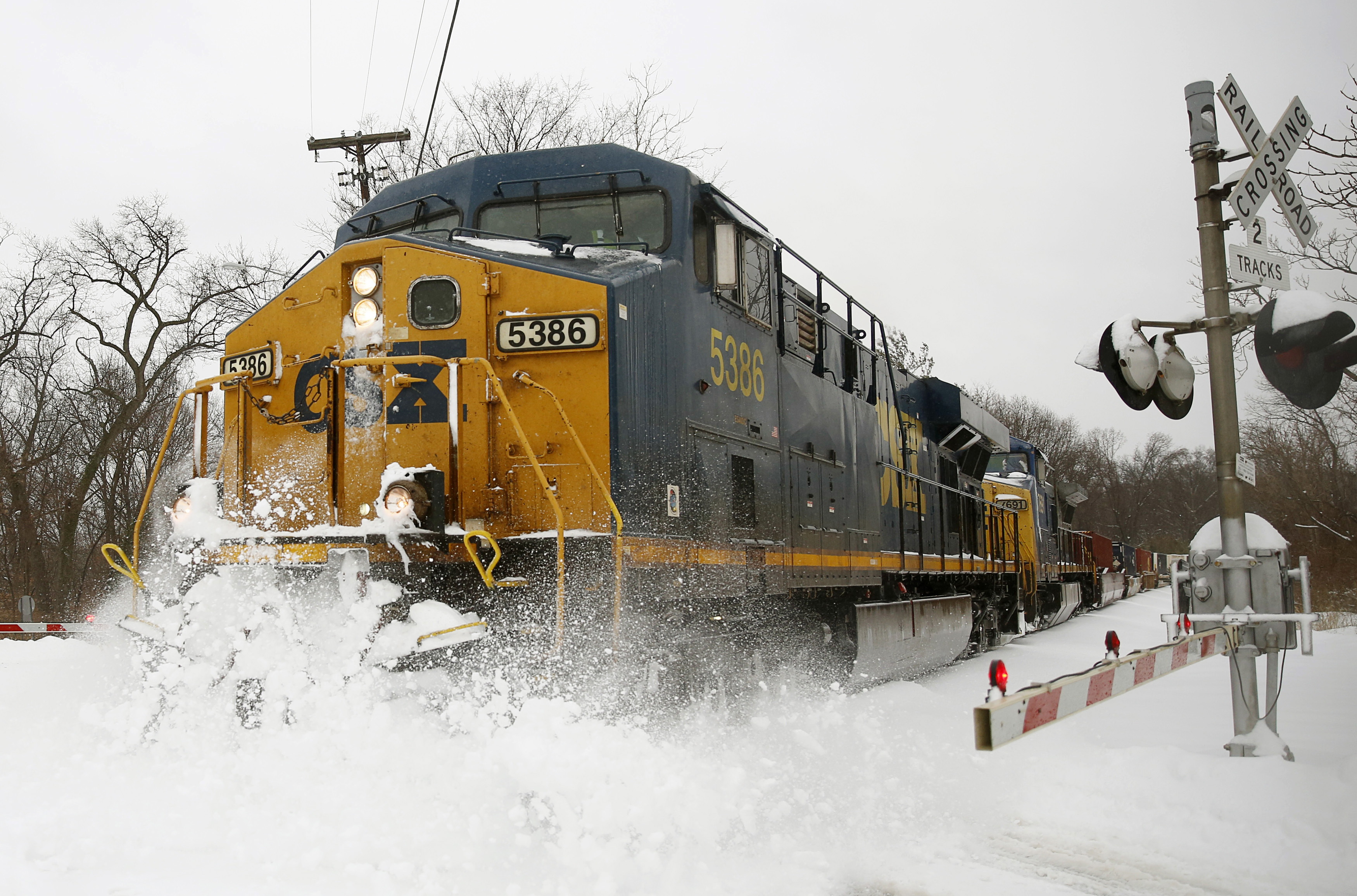 A CSX freight train blasts through high snow at a crossing in Silver Spring, Maryland, February 13, 2014.  REUTERS/Gary Cameron 