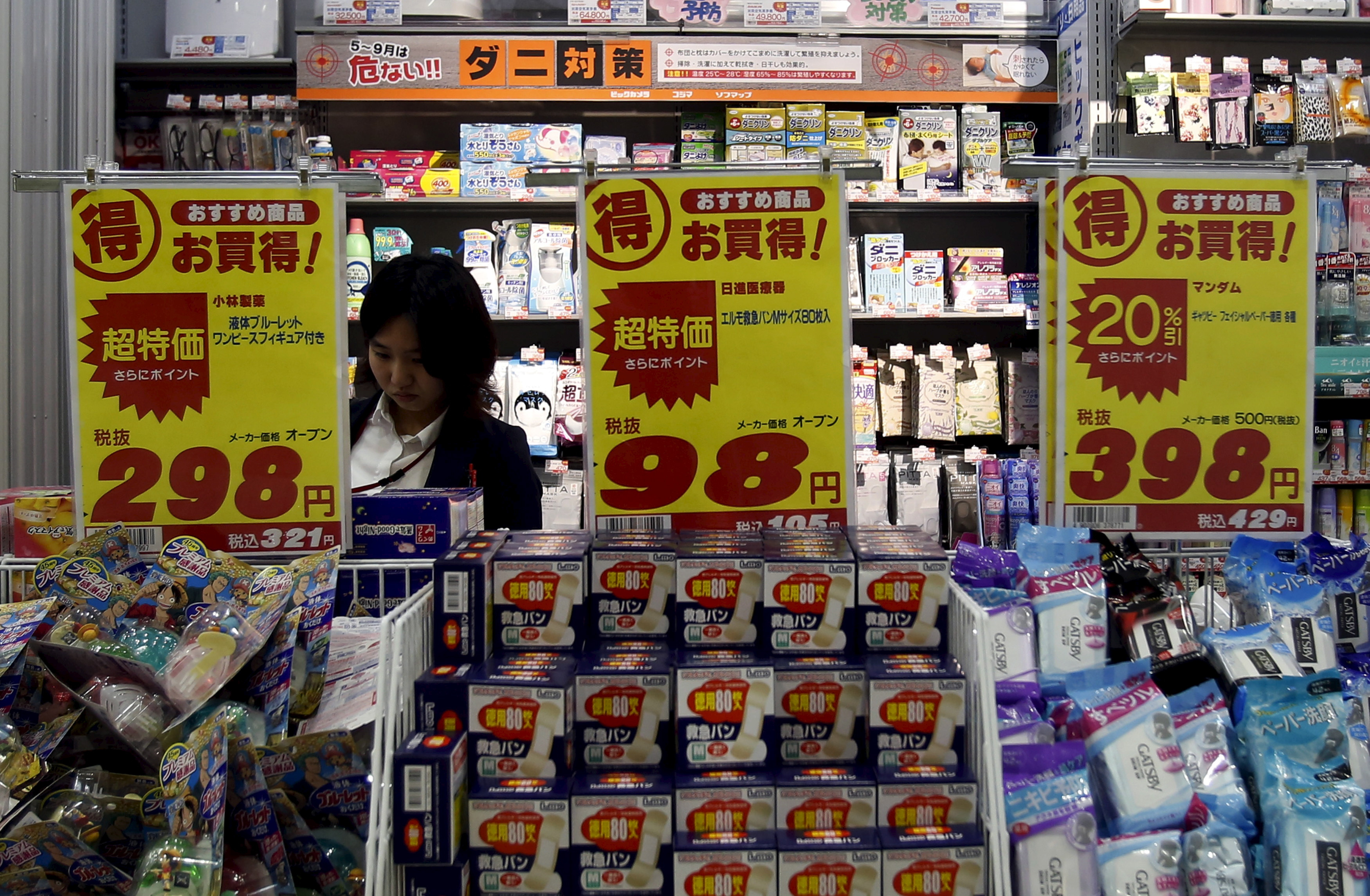A shopper is seen between price boards at a drug store in Tokyo