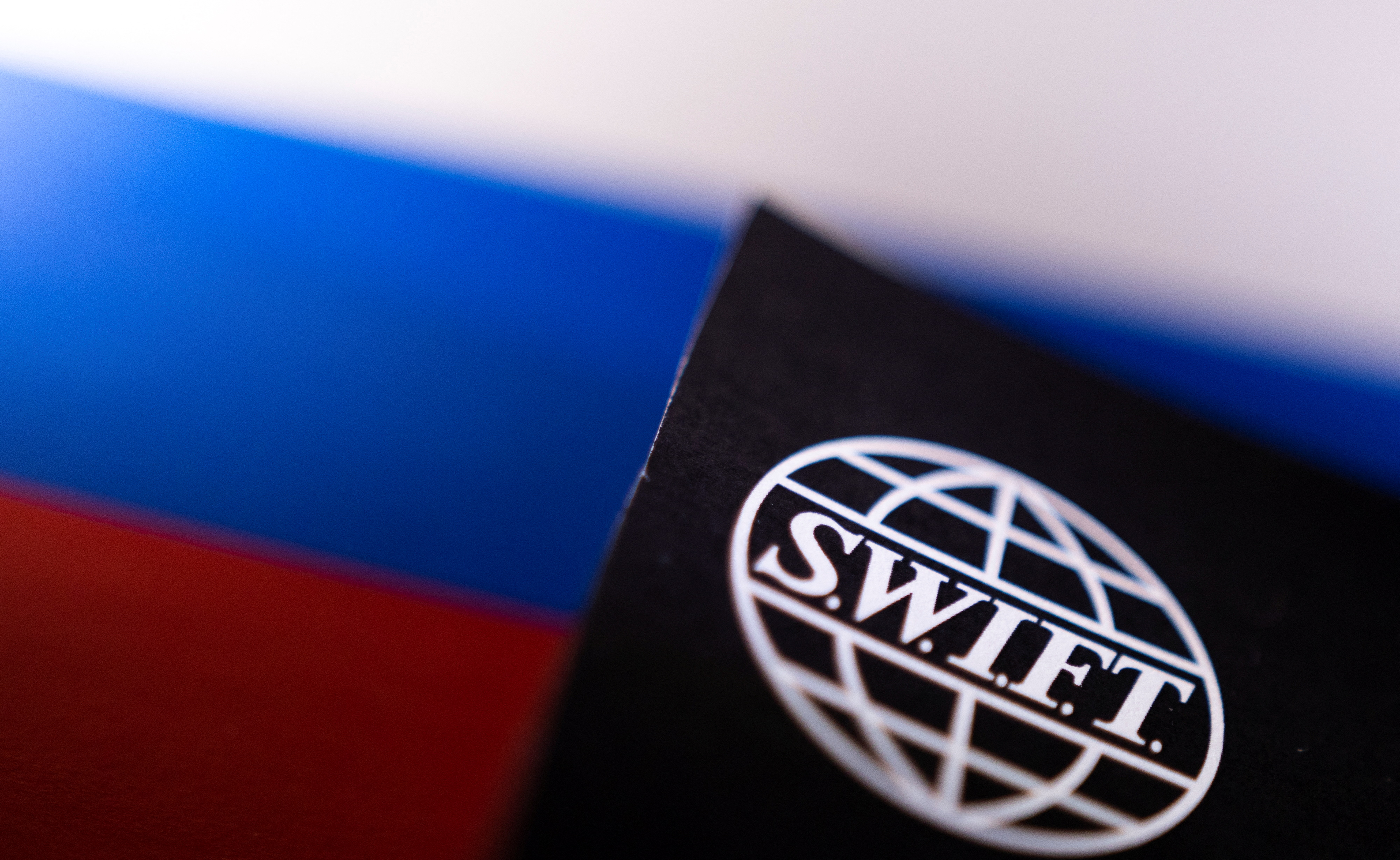 Swift logo is placed on a Russian flag are seen in this illustration taken, Bosnia and Herzegovina, February 25, 2022. REUTERS/Dado Ruvic/Illustration