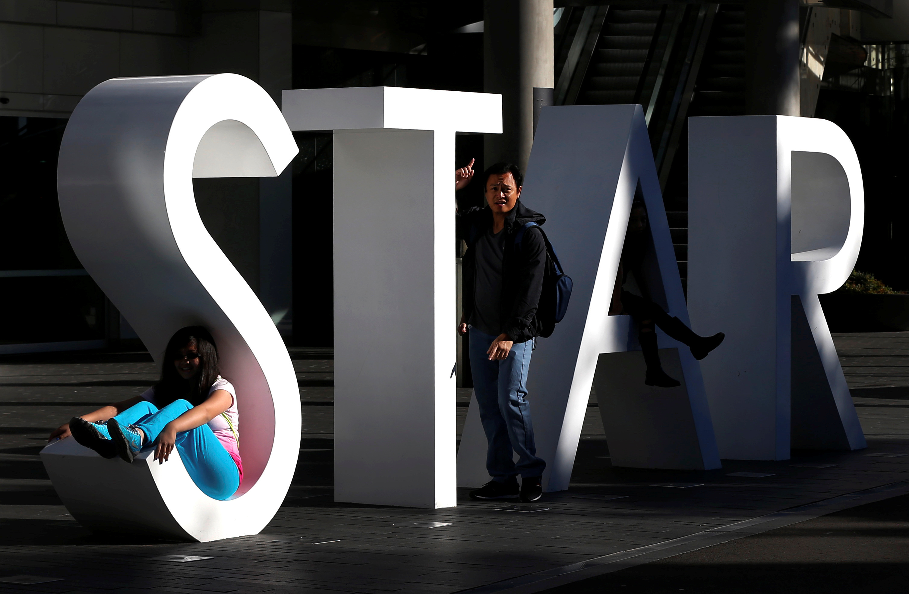 File photo of tourists posing for pictures at the main sign of The Star Casino at Pyrmont Bay in Sydney