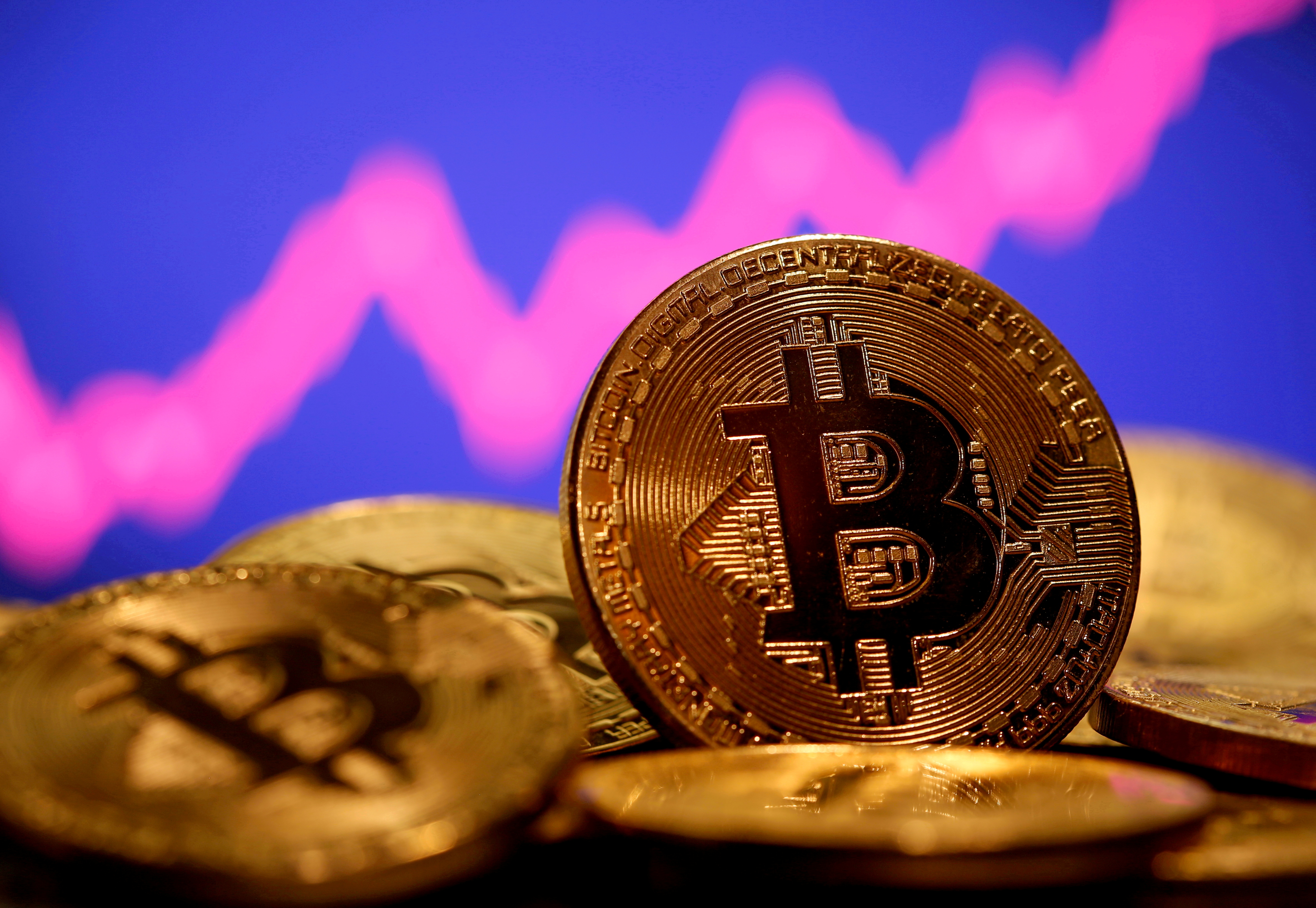 A representation of virtual currency Bitcoin is seen in front of a stock graph in this illustration taken January 8, 2021. REUTERS/Dado Ruvic