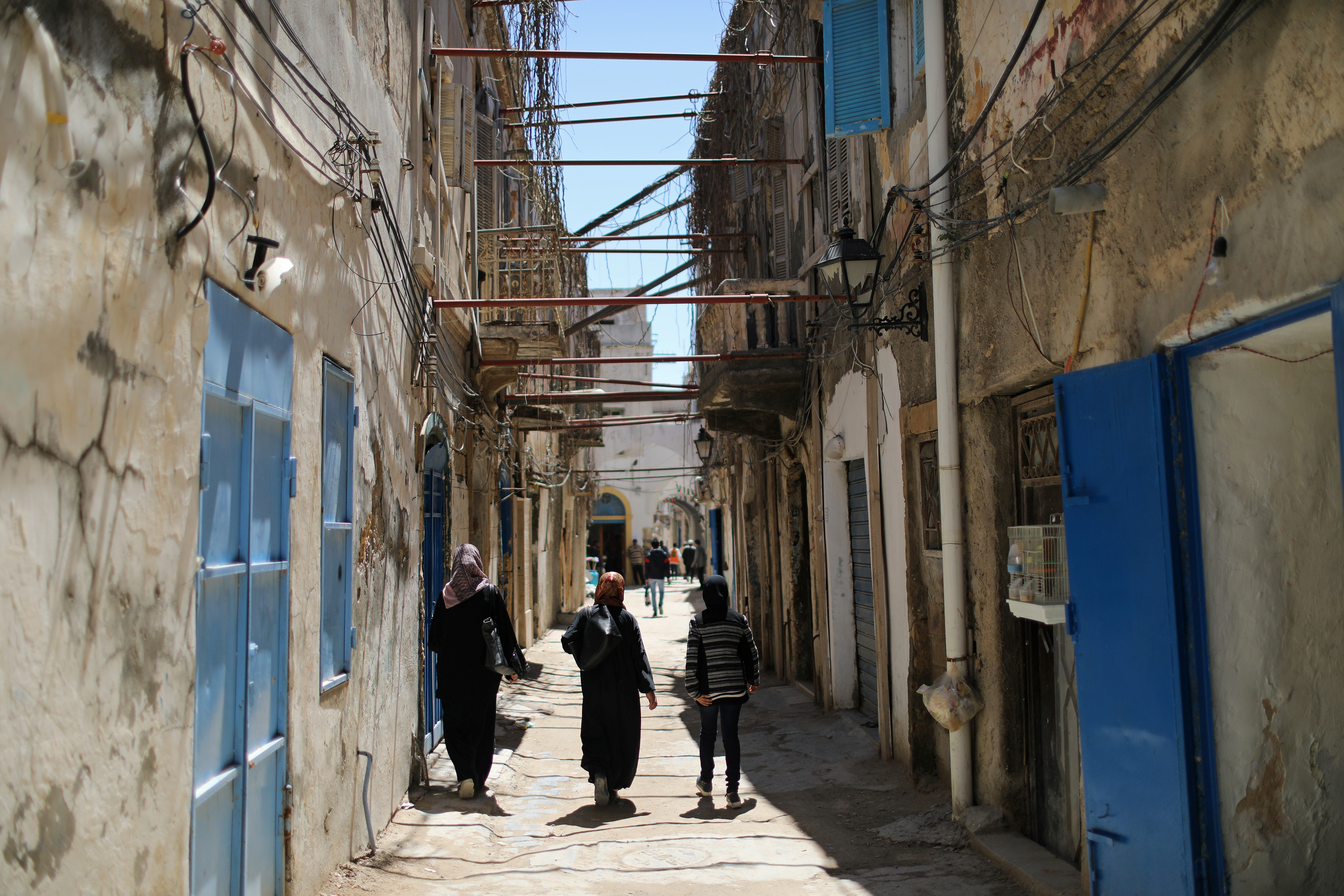 Libyan people walk at the old city of Tripoli