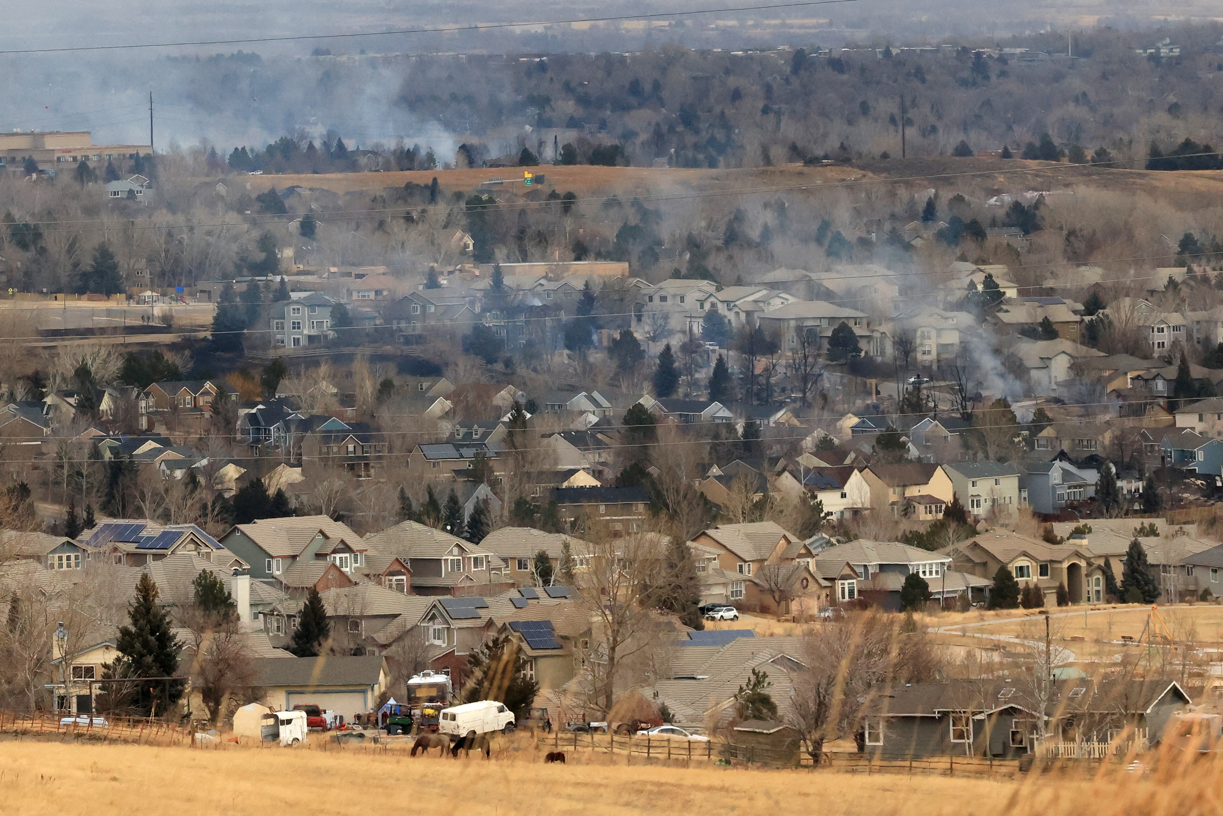 Smoke rises a day after wind-driven wildfires prompted evacuation orders in Superior