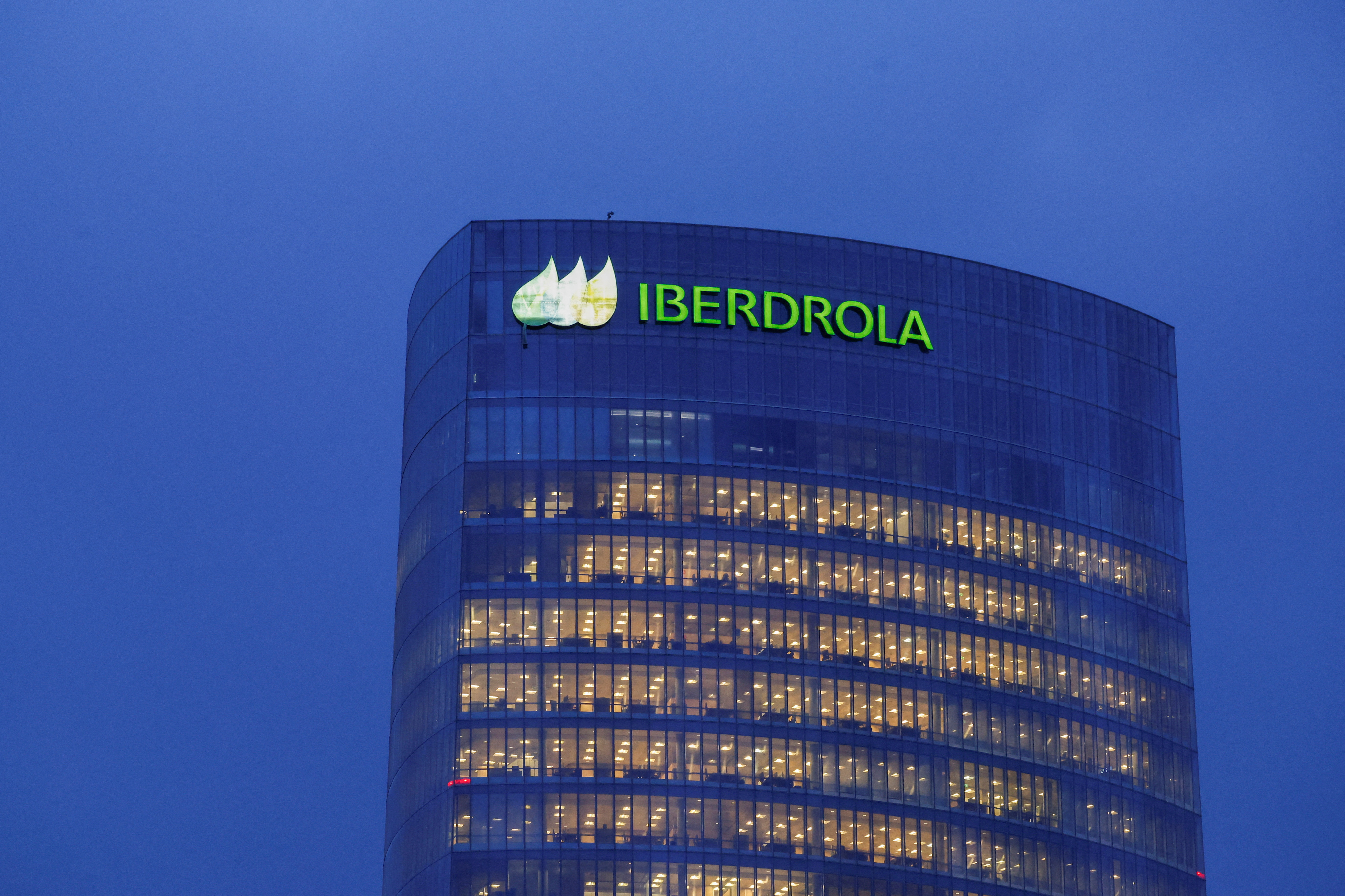 Logotype of Spanish utilities company Iberdrola is illuminated atop the Iberdrola Tower, in Bilbao