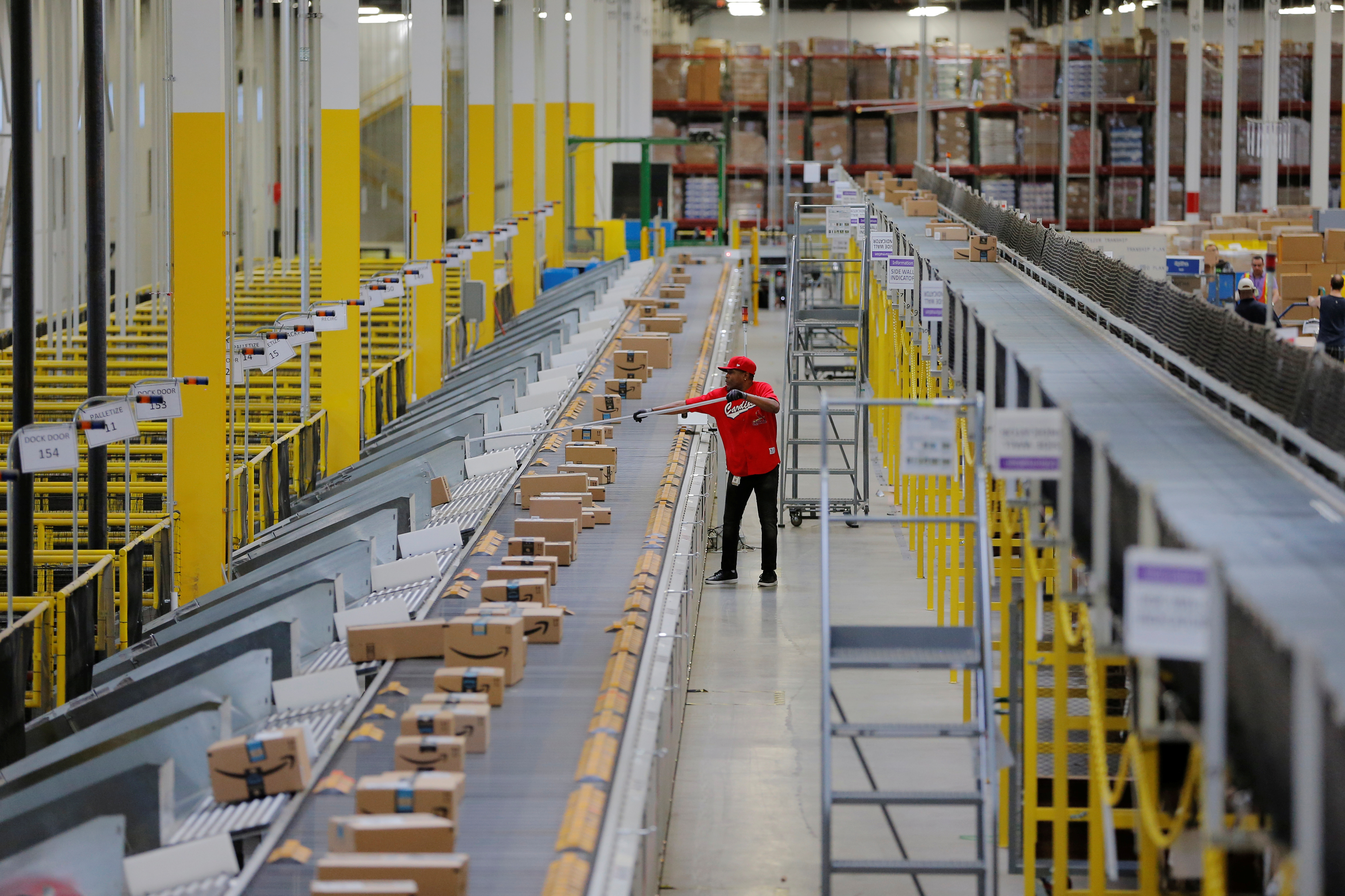 A worker clears a machine jam inside of an Amazon fulfillment center in Robbinsville, New Jersey