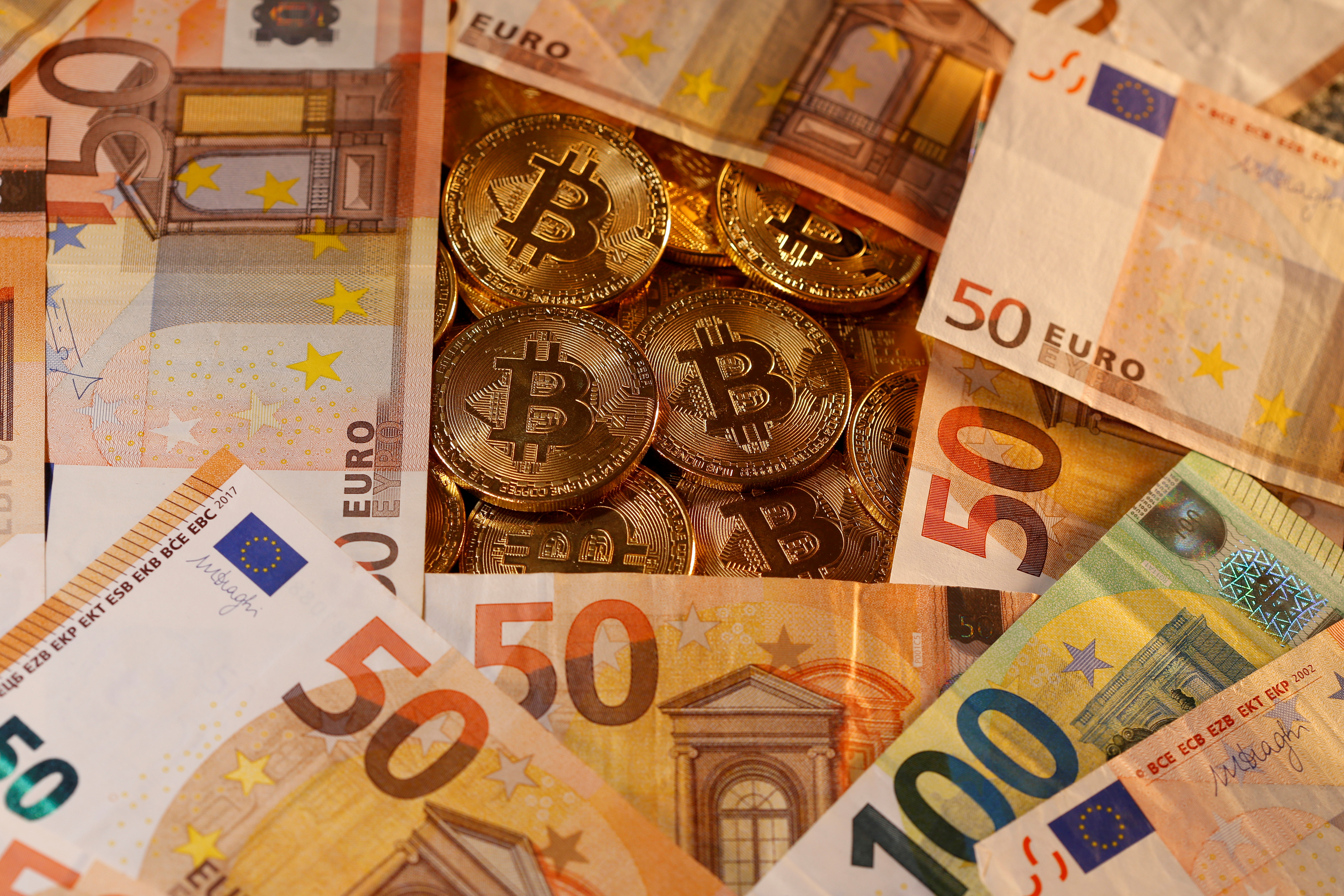 Representations of virtual currency Bitcoin and euro banknotes are seen in this picture illustration