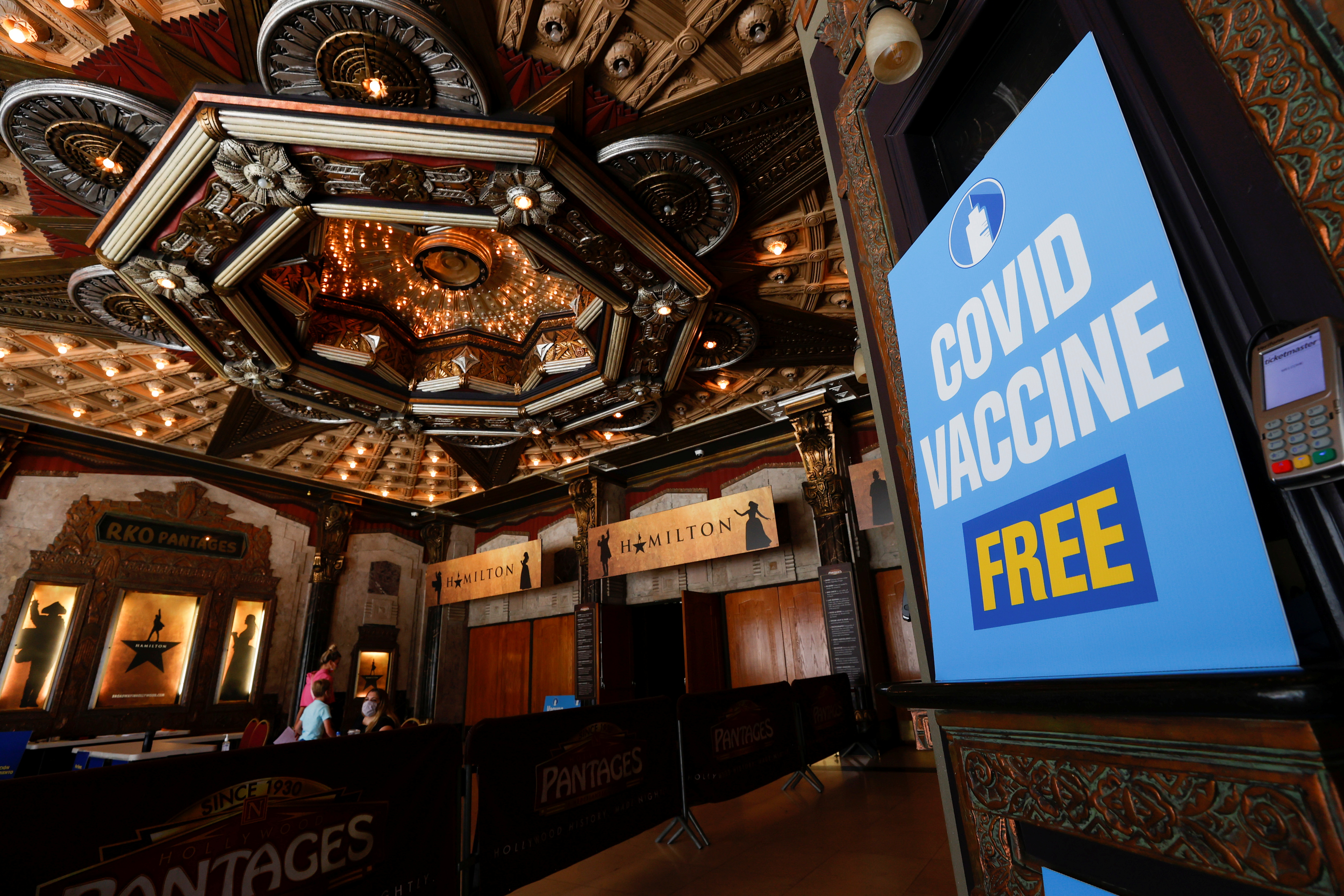 People walk in to receive a coronavirus disease (COVID-19) vaccine with a chance to win a pair of tickets to see 