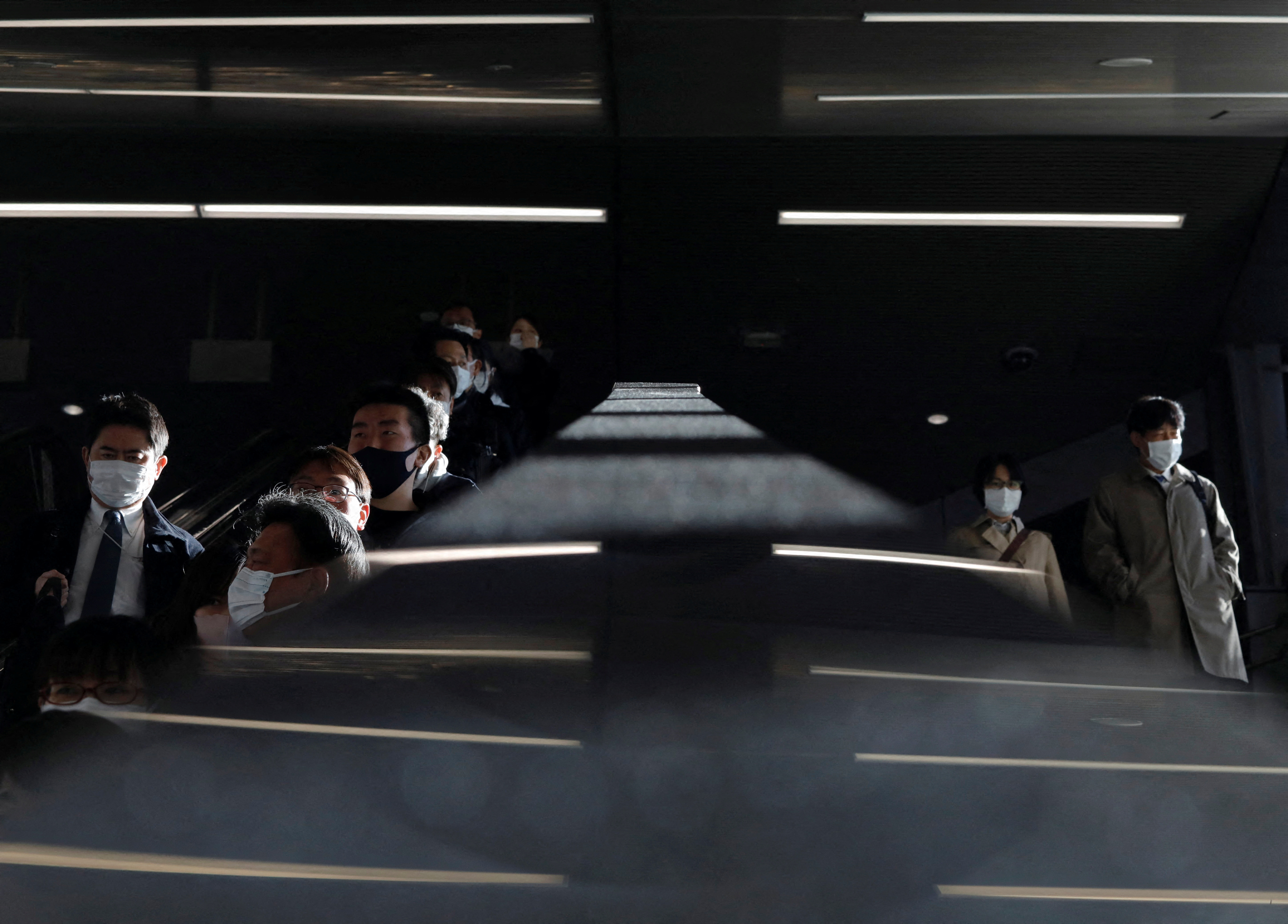 Passengers wearing protective face masks are pictured at a train station, amid the COVID-19 pandemic, in Tokyo