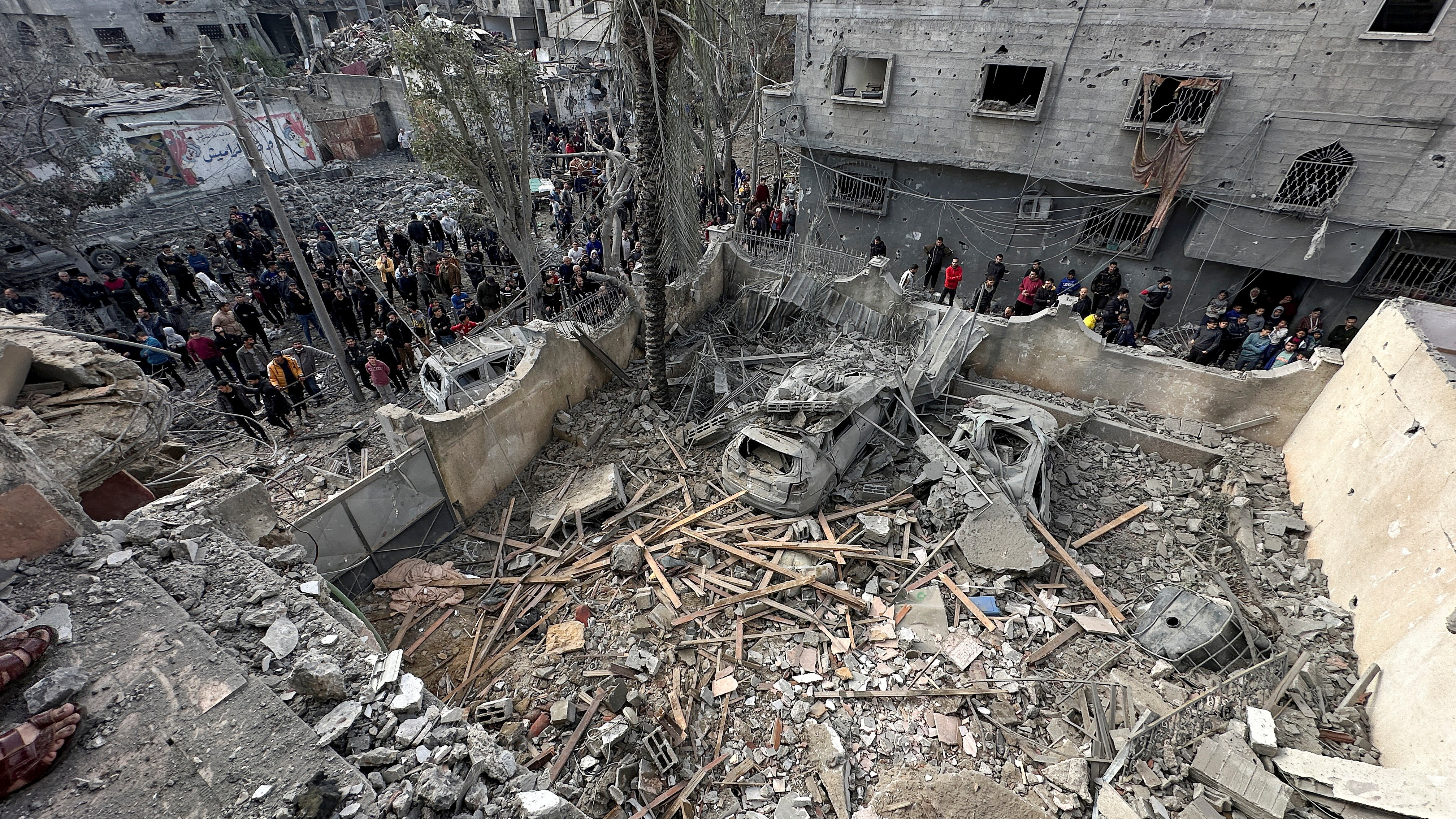 Palestinians inspect the site of an Israeli strike on a house in Jabalia