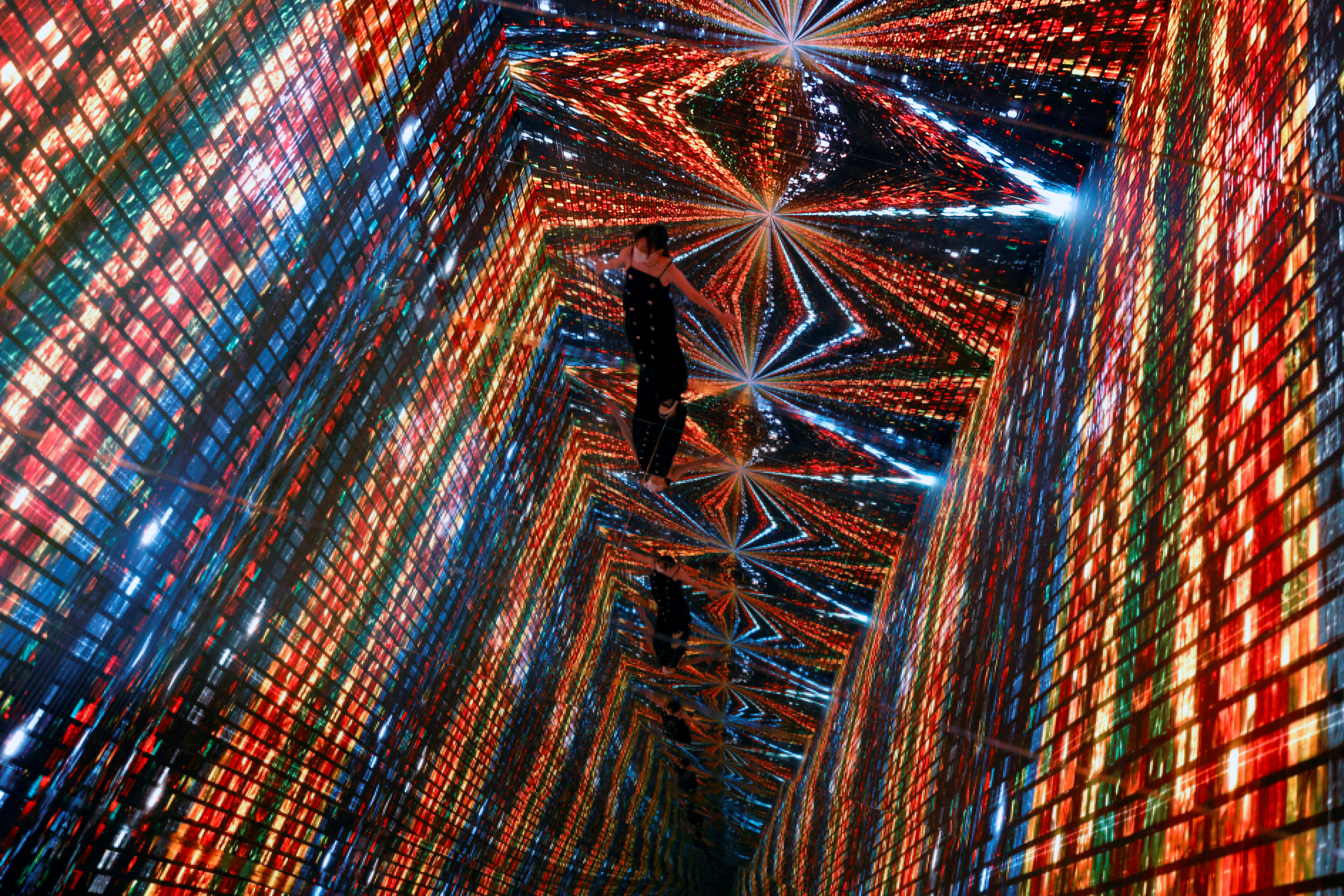 A visitor is pictured in front of an immersive art installation titled "Machine Hallucinations — Space: Metaverse" by media artist Refik Anadol, which will be converted into NFT and auctioned online at Sotheby's, at the Digital Art Fair, in Hong Kong, China September 30, 2021. REUTERS/Tyrone Siu