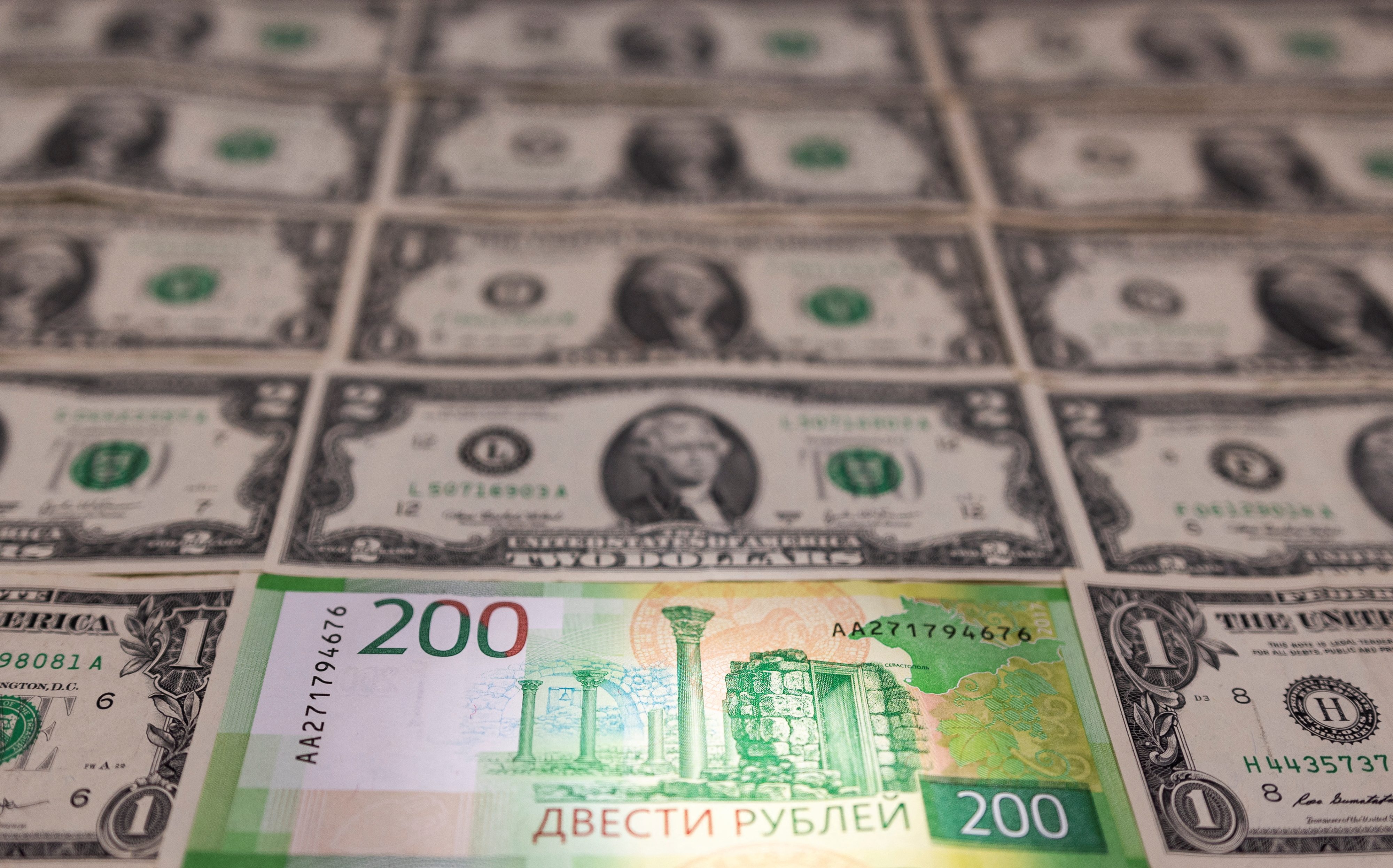 Illustration shows Russian Rouble banknote is placed on U.S. Dollar banknotes