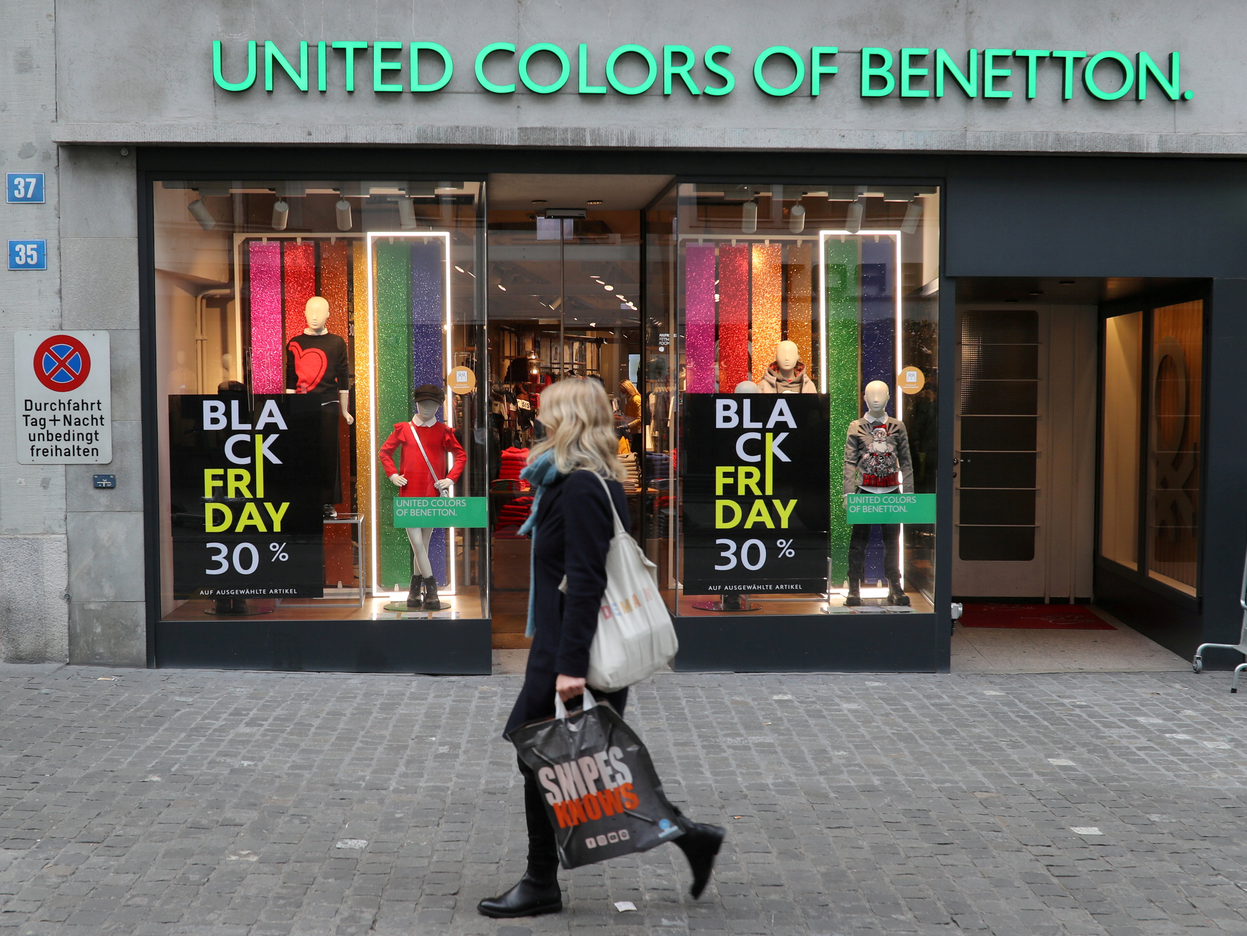Posters offering special discount on Black Friday sales are seen in front of a United Colors of Benetton kid's fashion store in Zurich