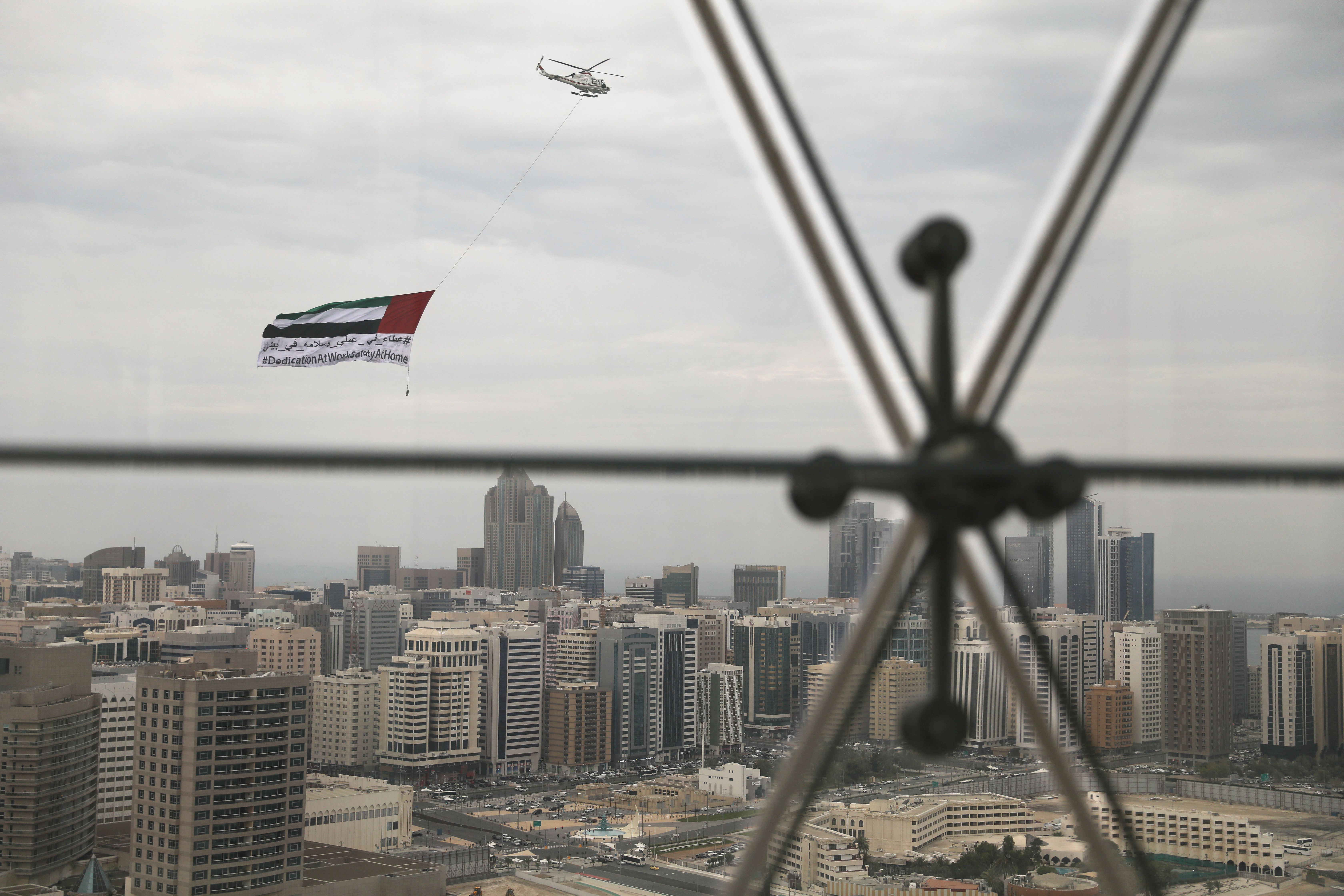 A helicopter flies over the downtown skyline, amid the coronavirus disease (COVID-19) outbreak, as seen from the Cleveland Clinic hospital in Abu Dhabi, United Arab Emirates, April 20, 2020. REUTERS/Christopher Pike