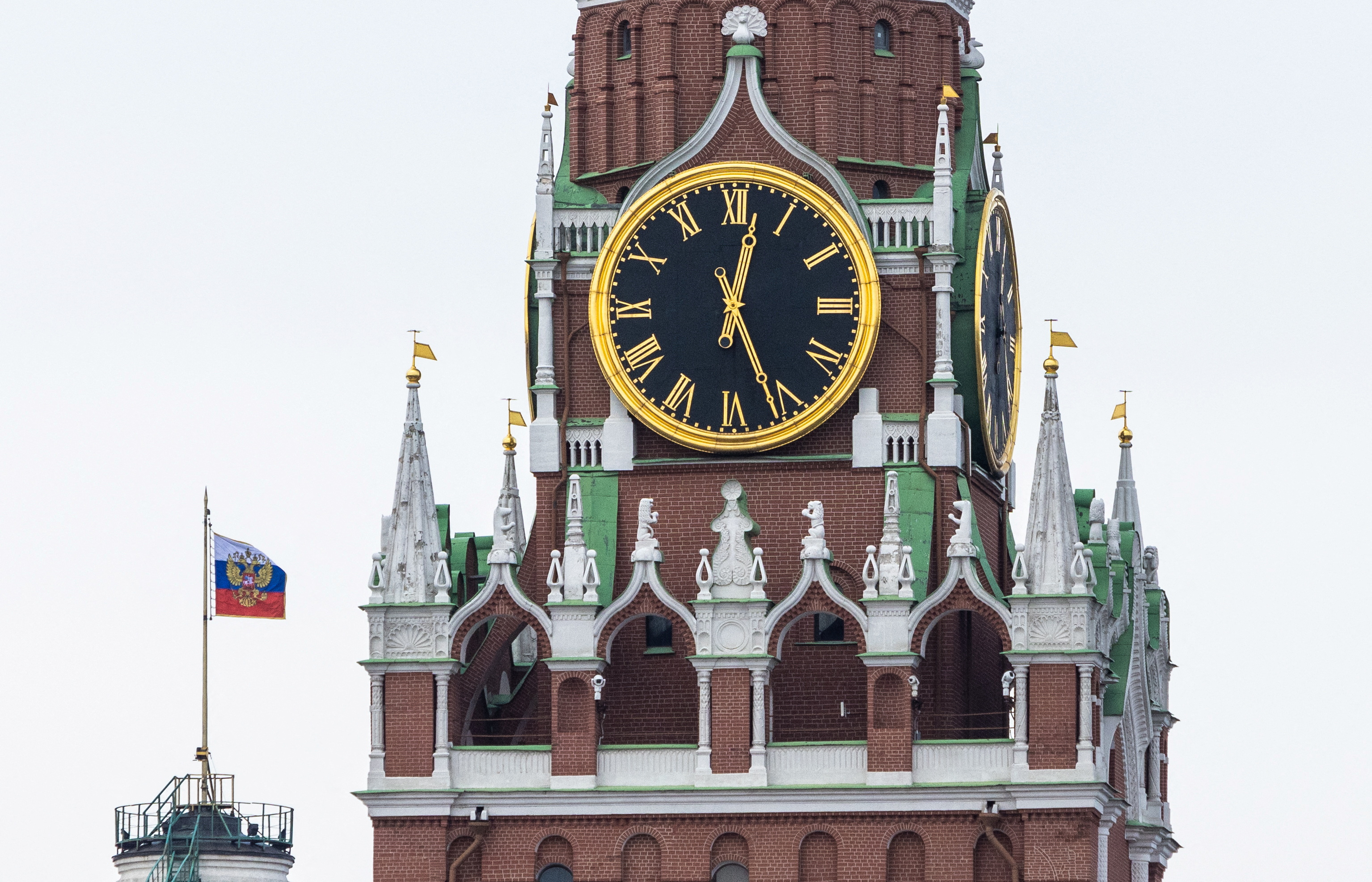 Russian flag with coat of arms is seen next to Kremlin's Spasskaya Tower in Moscow's