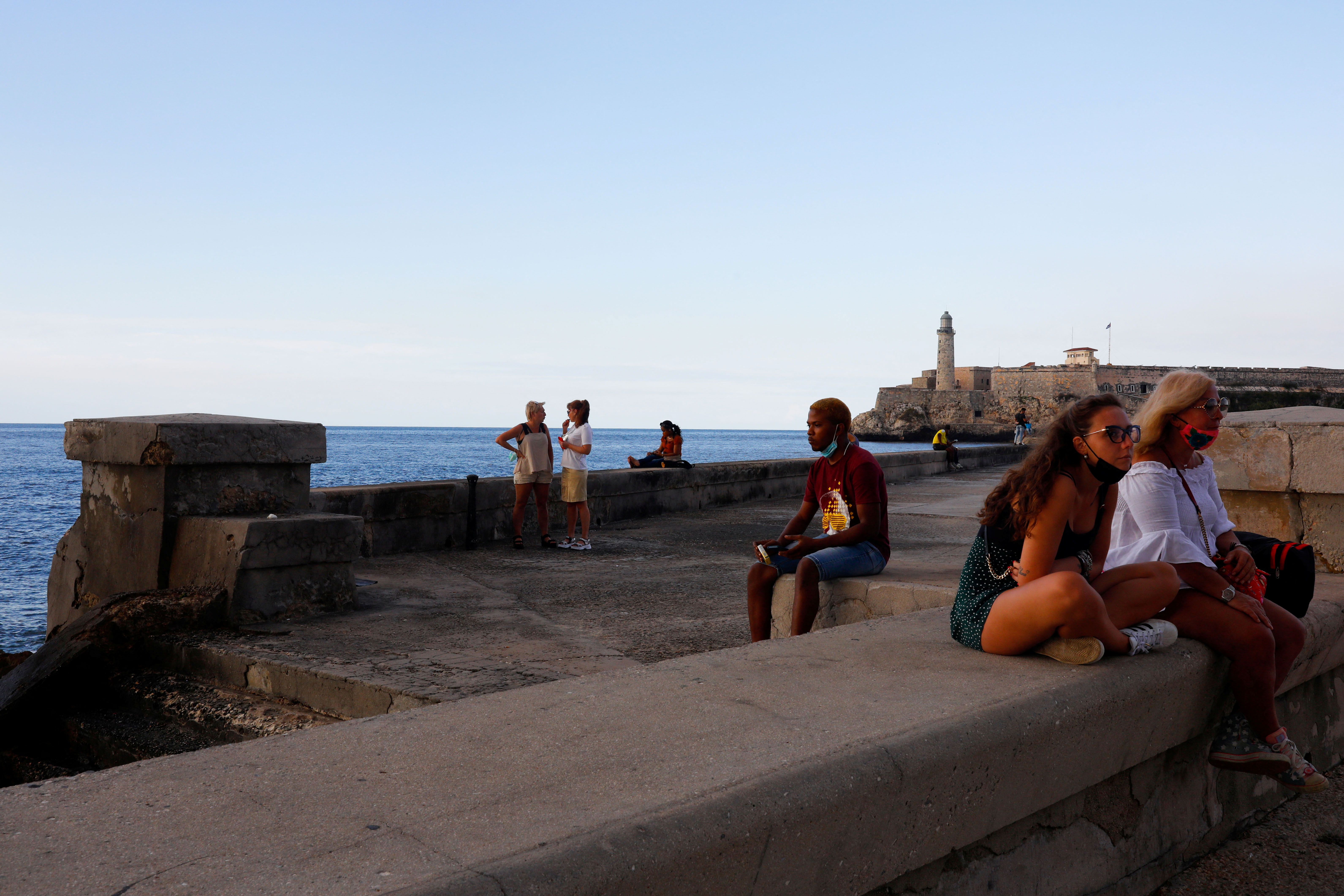 People sit at the seafront of El Malecon in Havana