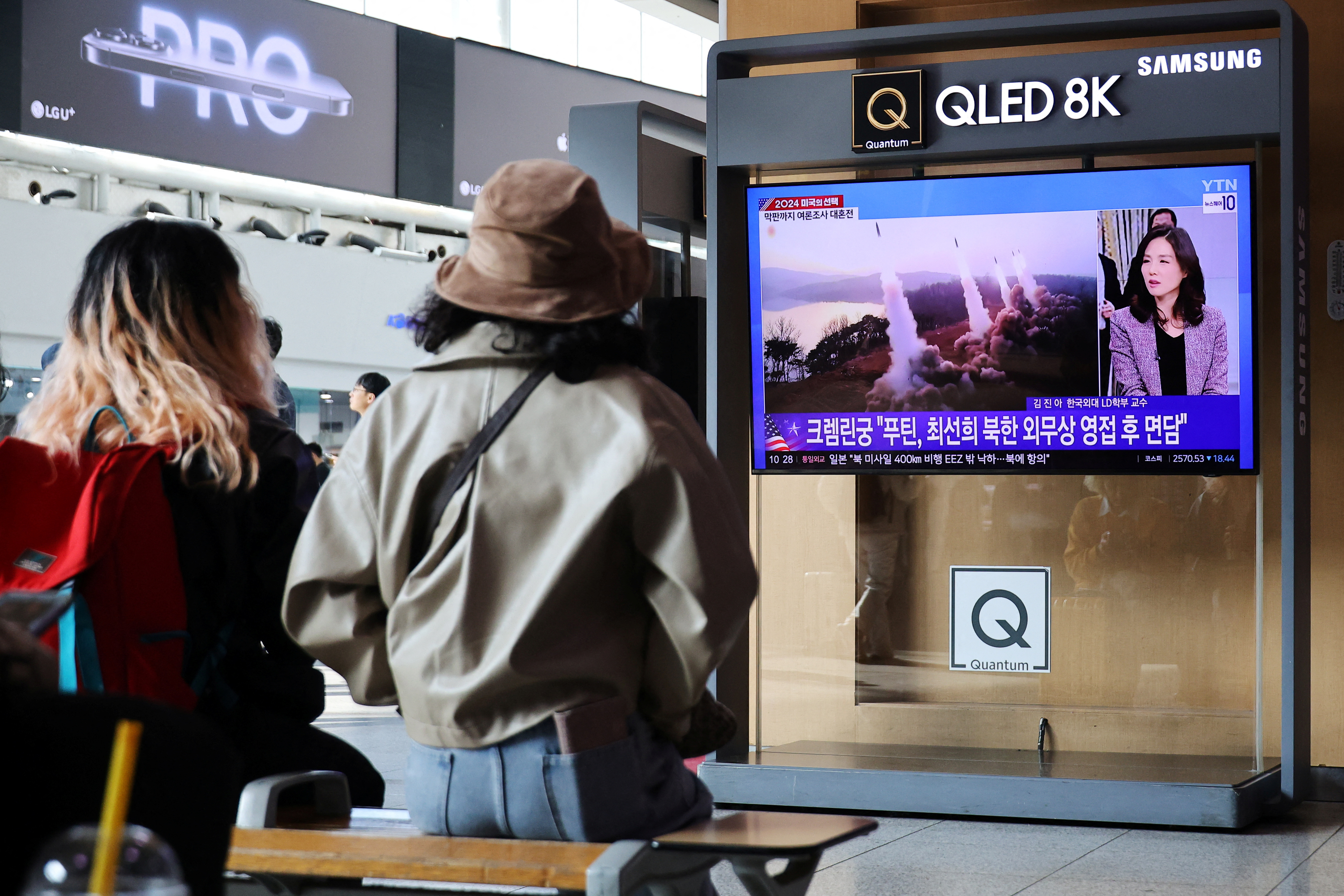 People watch a TV broadcasting a news report on North Korea firing missiles that flew 400 km after lifting off at around 7:30 a.m. from Sariwon, just south of the capital Pyongyang, at a railway station in Seoul