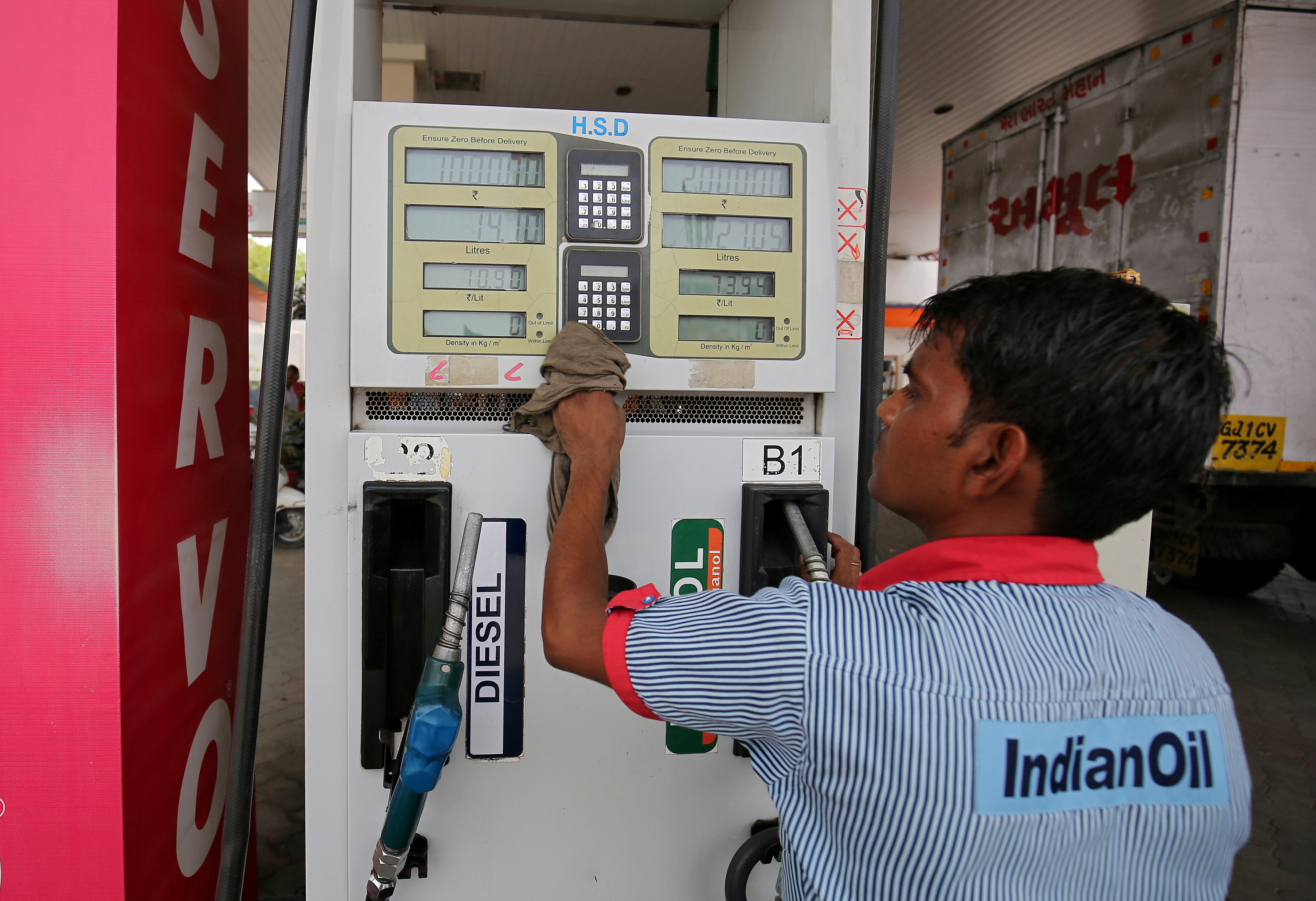 Indian Oil fuel pump attendant  cleans a pump at a filling station in Ahmedabad
